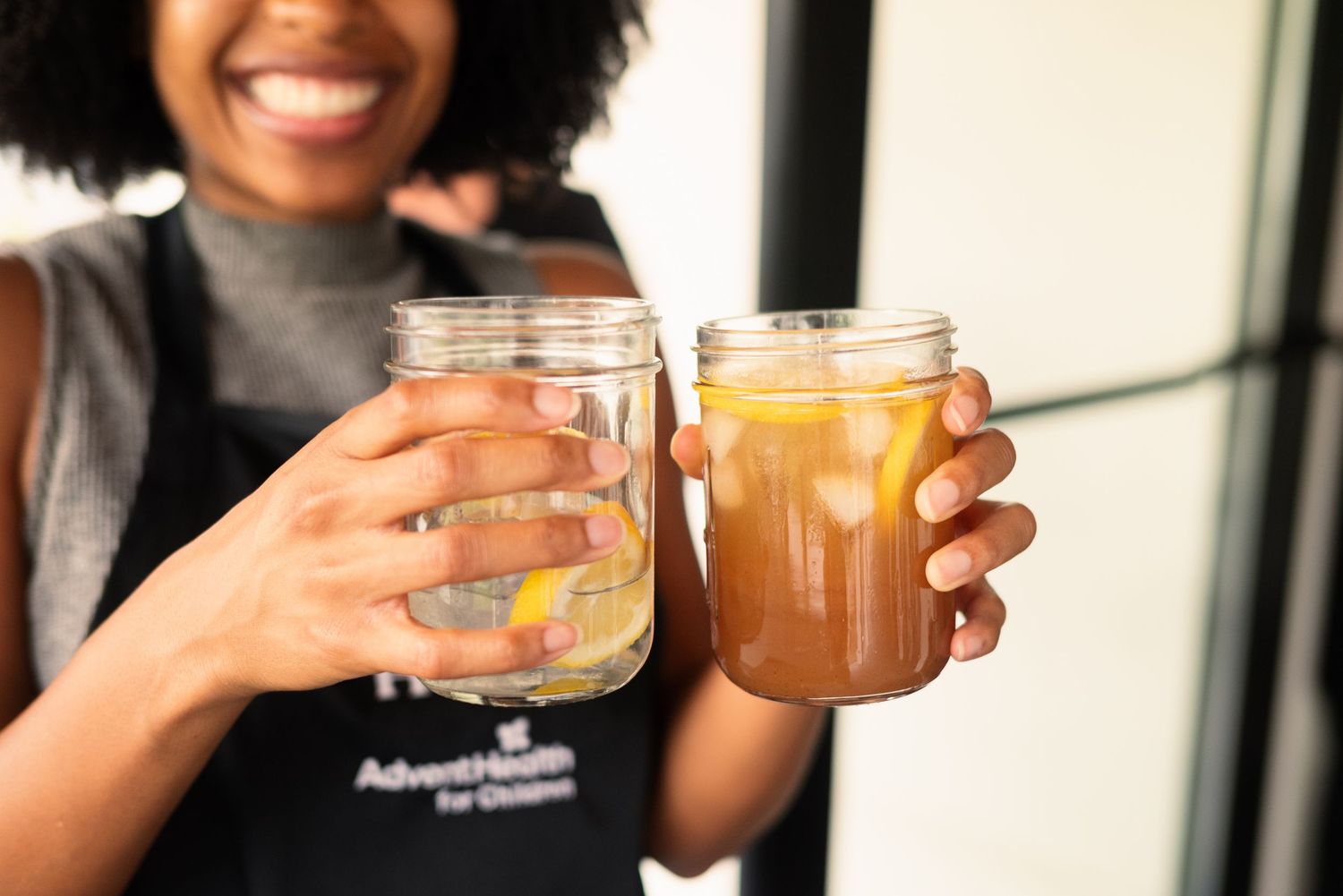 People holding mason jar drinks at a social gathering.