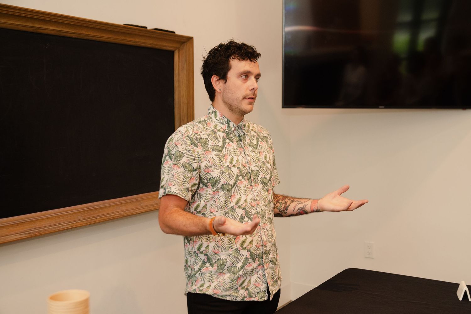 Presenter speaking animatedly to an audience in a modern conference room setting.