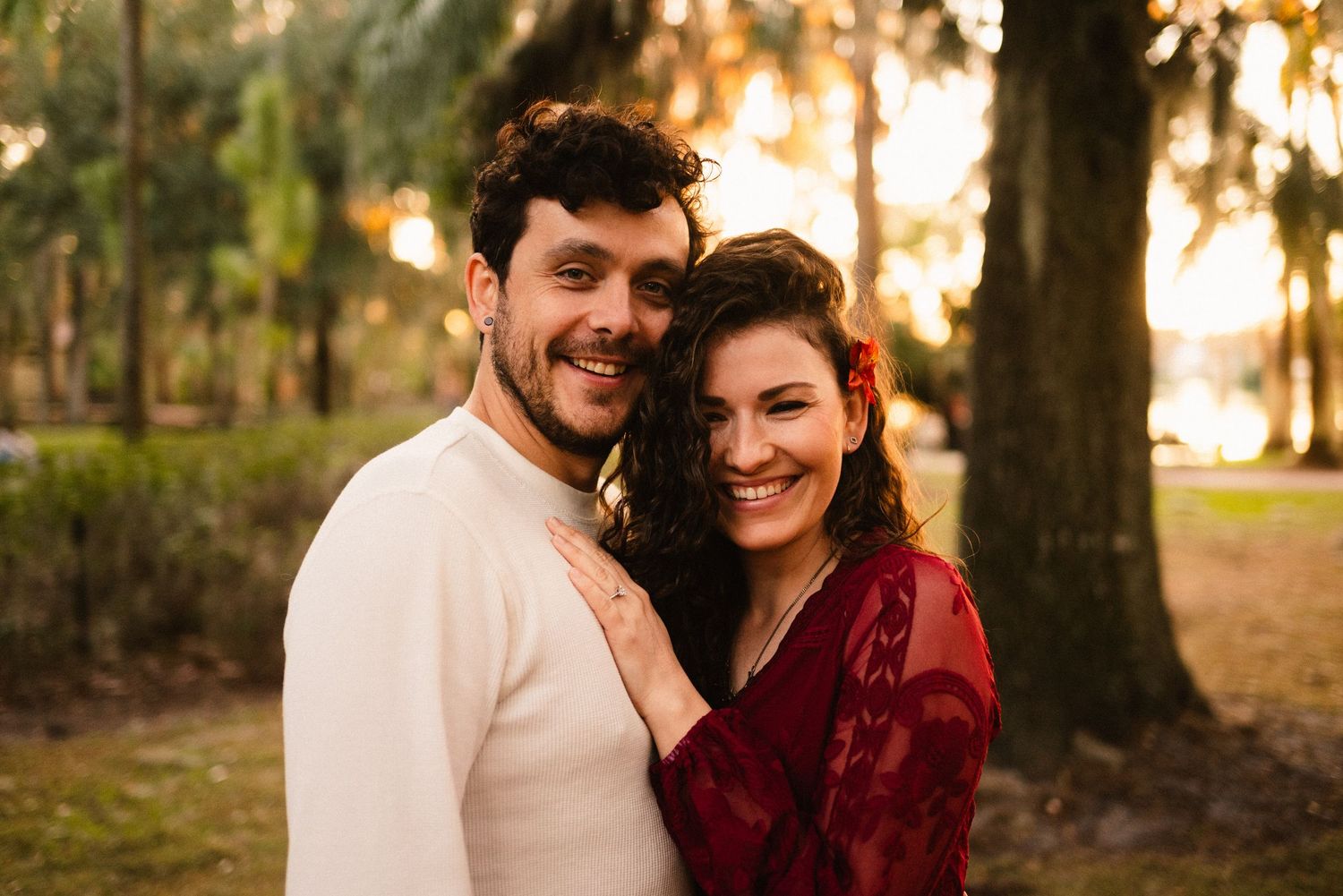 Romantic couple laughs together during a sunset photography session outdoors.