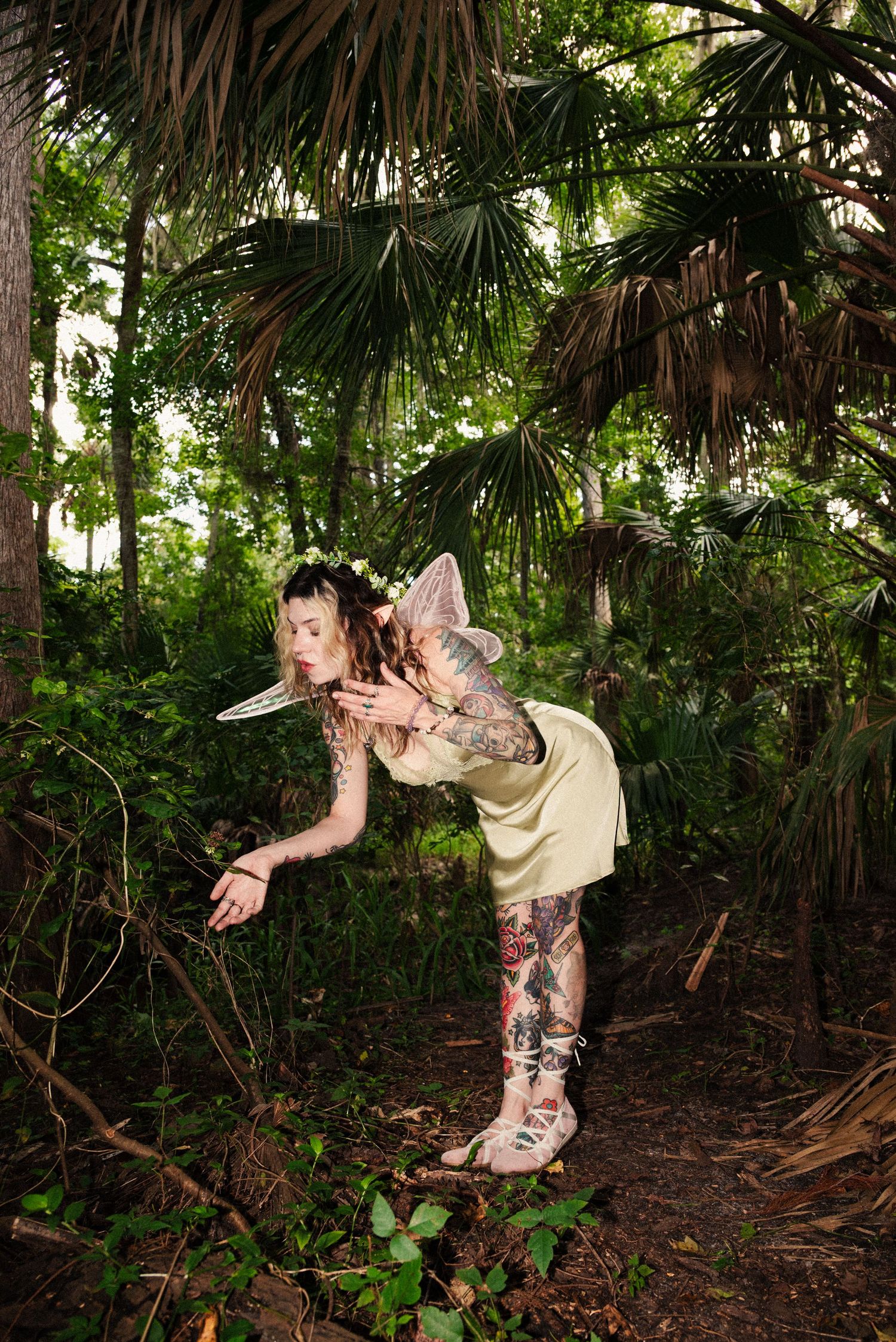 Fairy with iridescent wings balances artistically in a mystical forest setting.