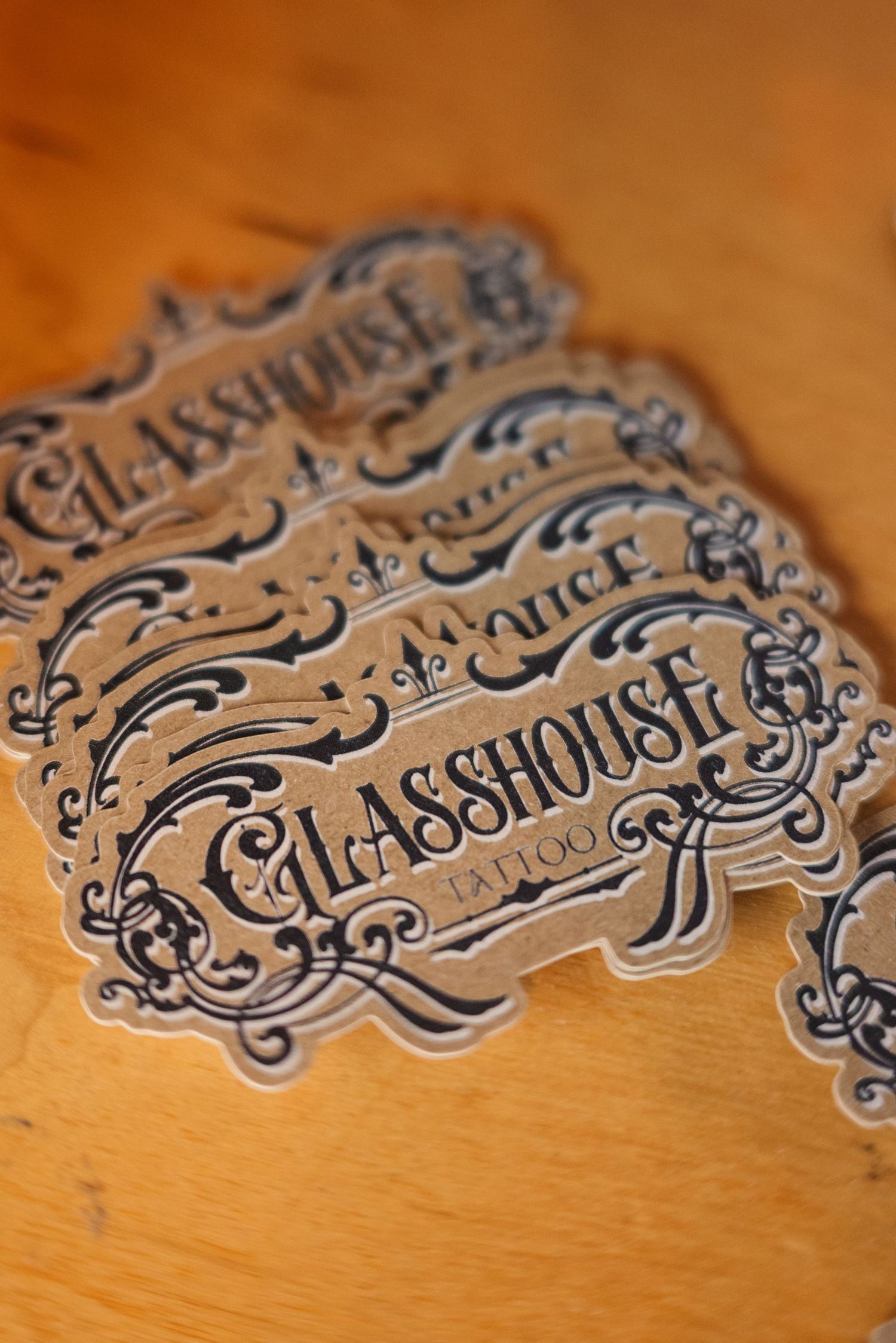 Ornate vintage-style typography design with decorative flourishes on wooden surface.
