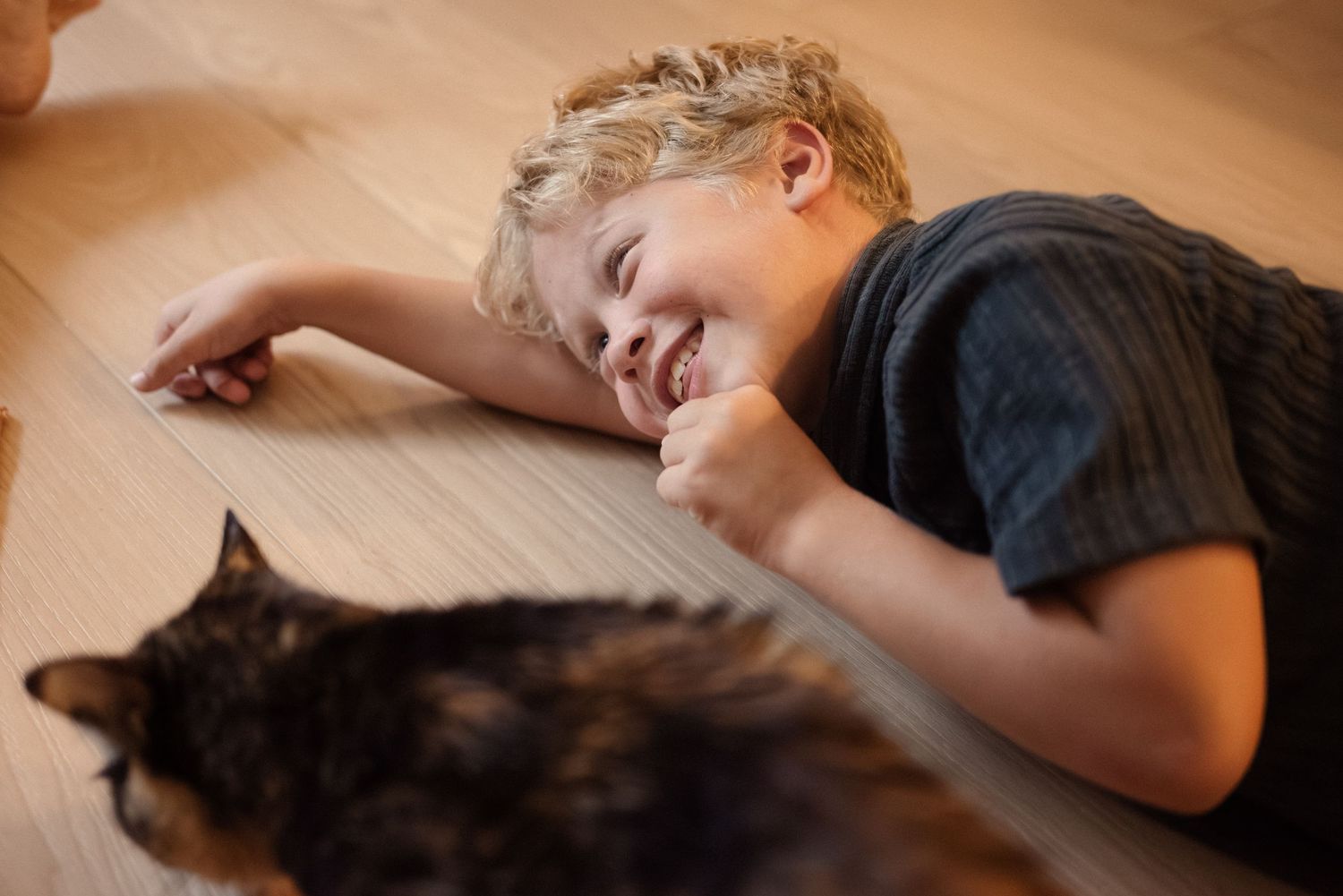 A sequence showing someone lying on the floor next to a cat in a cozy home setting.