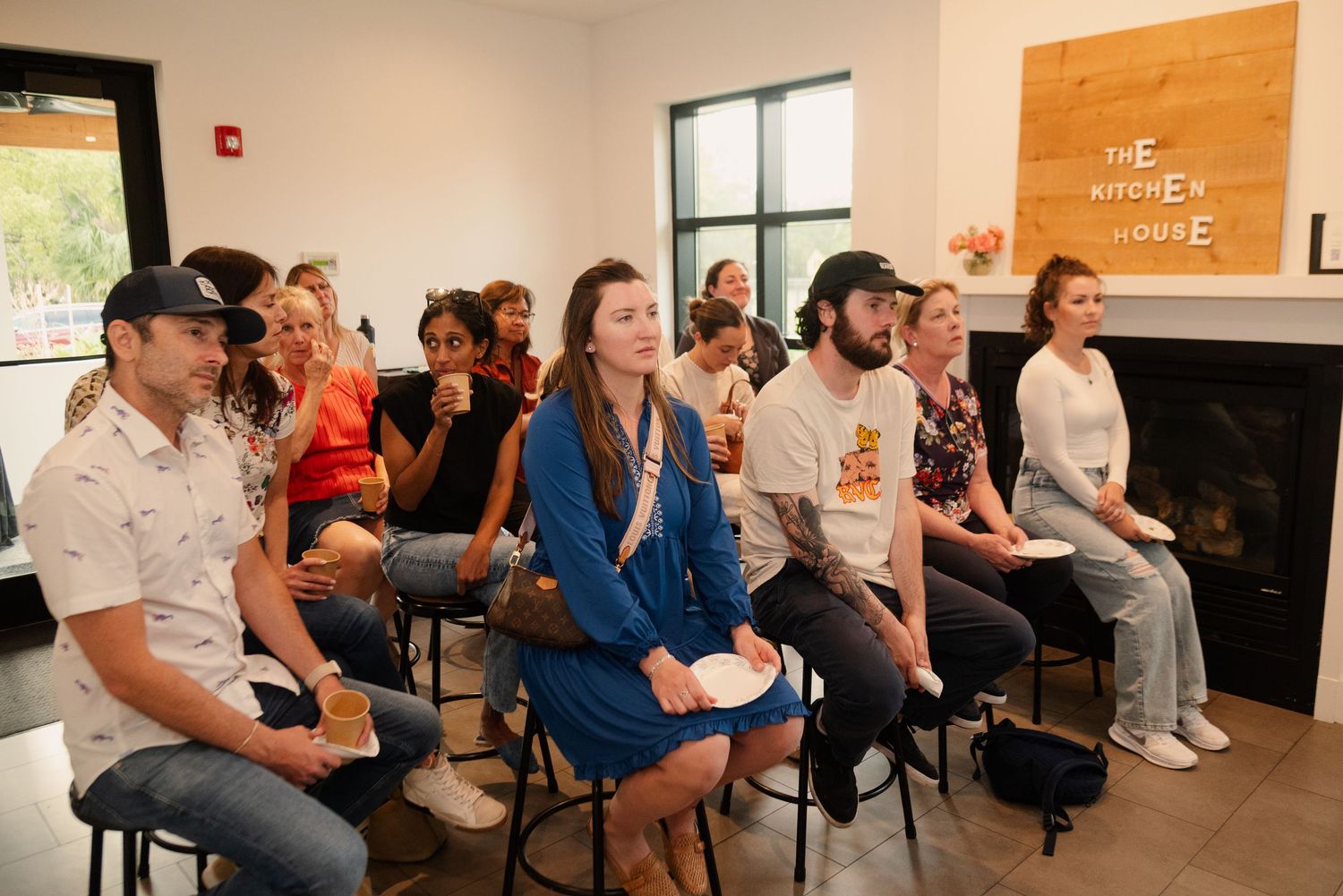 Wide angle view of a workshop space with attendees seated in rows facing the presenter.
