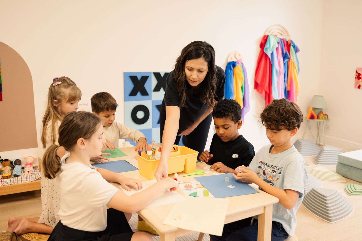 Children gathered around a table for an educational activity with their instructor.