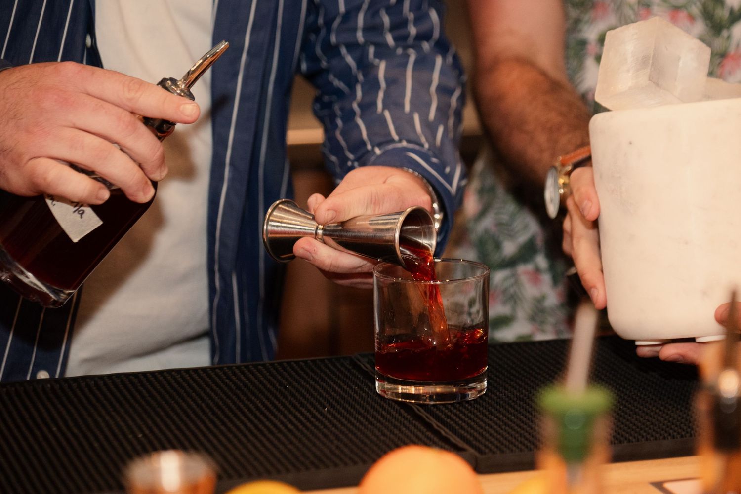 Close-up of hands preparing cocktails and beverages during a mixology workshop.