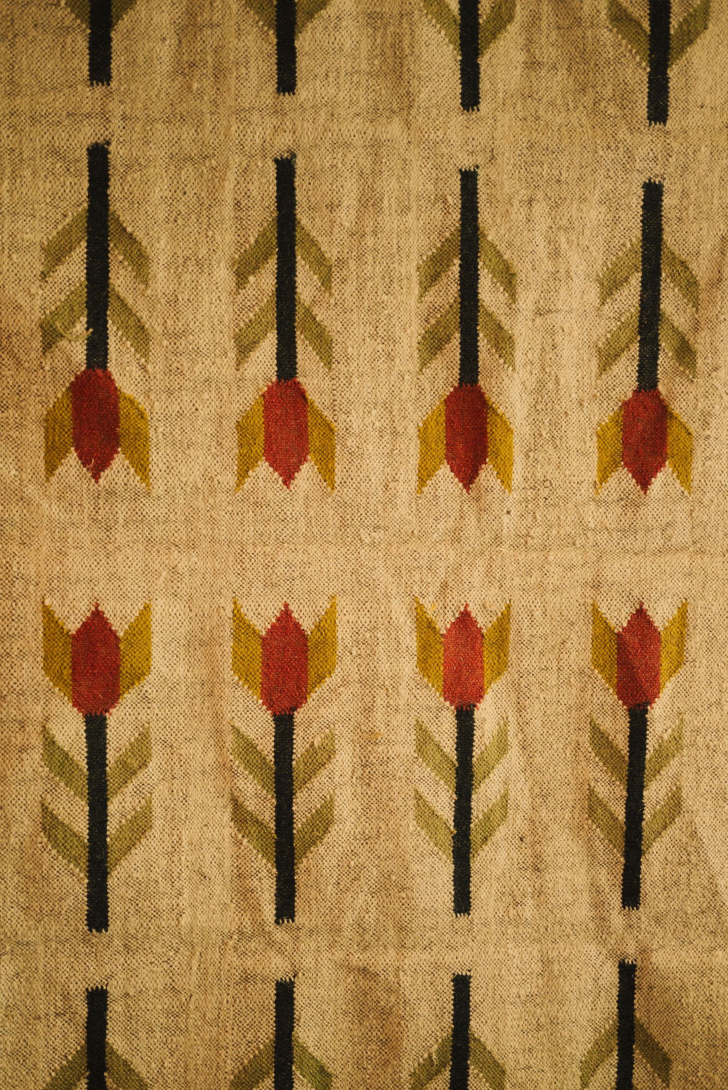 Retro textile pattern featuring geometric tulip designs in orange, yellow and black.