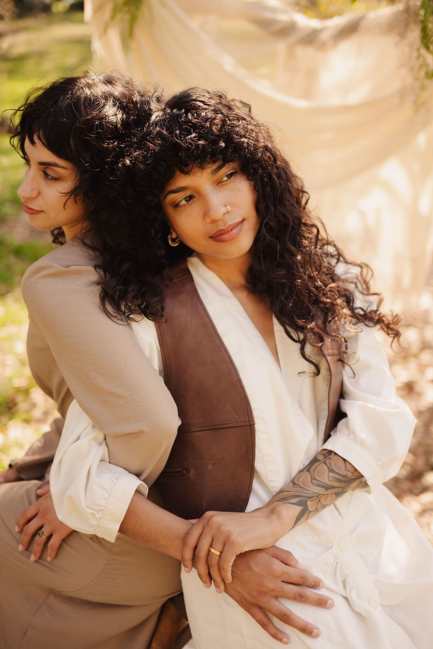 Intimate couples portrait session featuring contrasting brown and white outfits in natural setting.