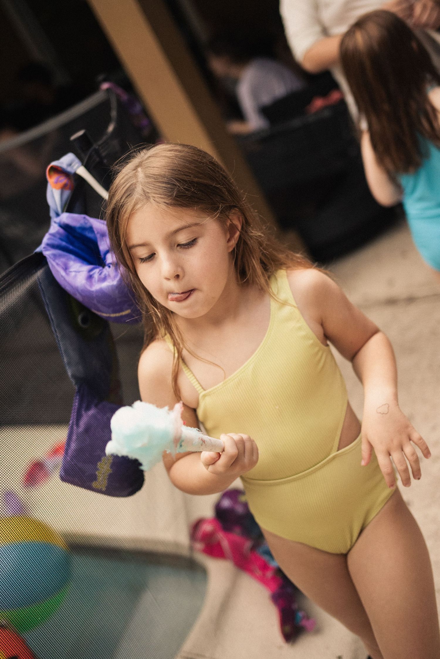 Young dancer in yellow leotard practicing dance moves in a studio.