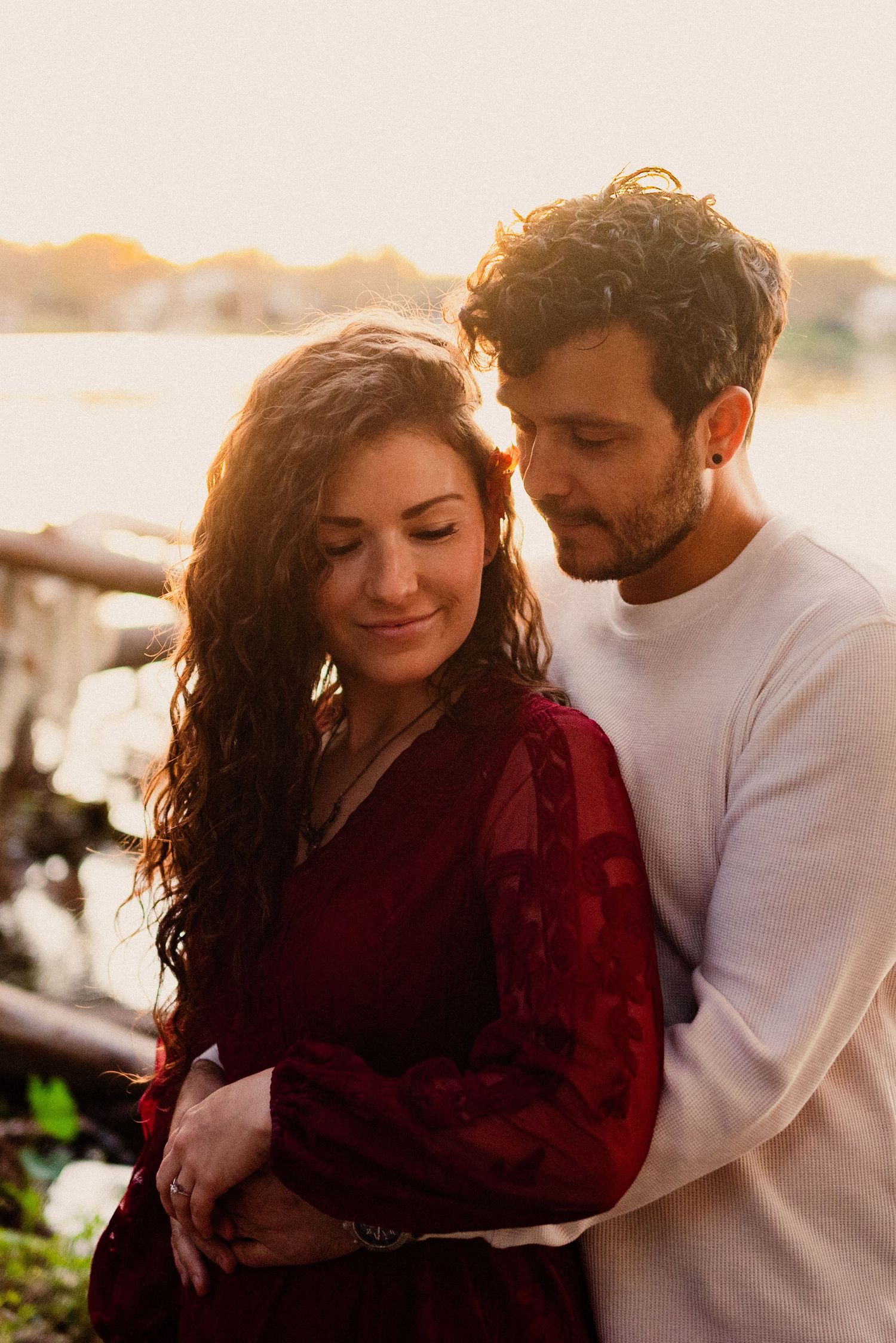 A romantic couple shares an intimate moment at golden hour outdoors.