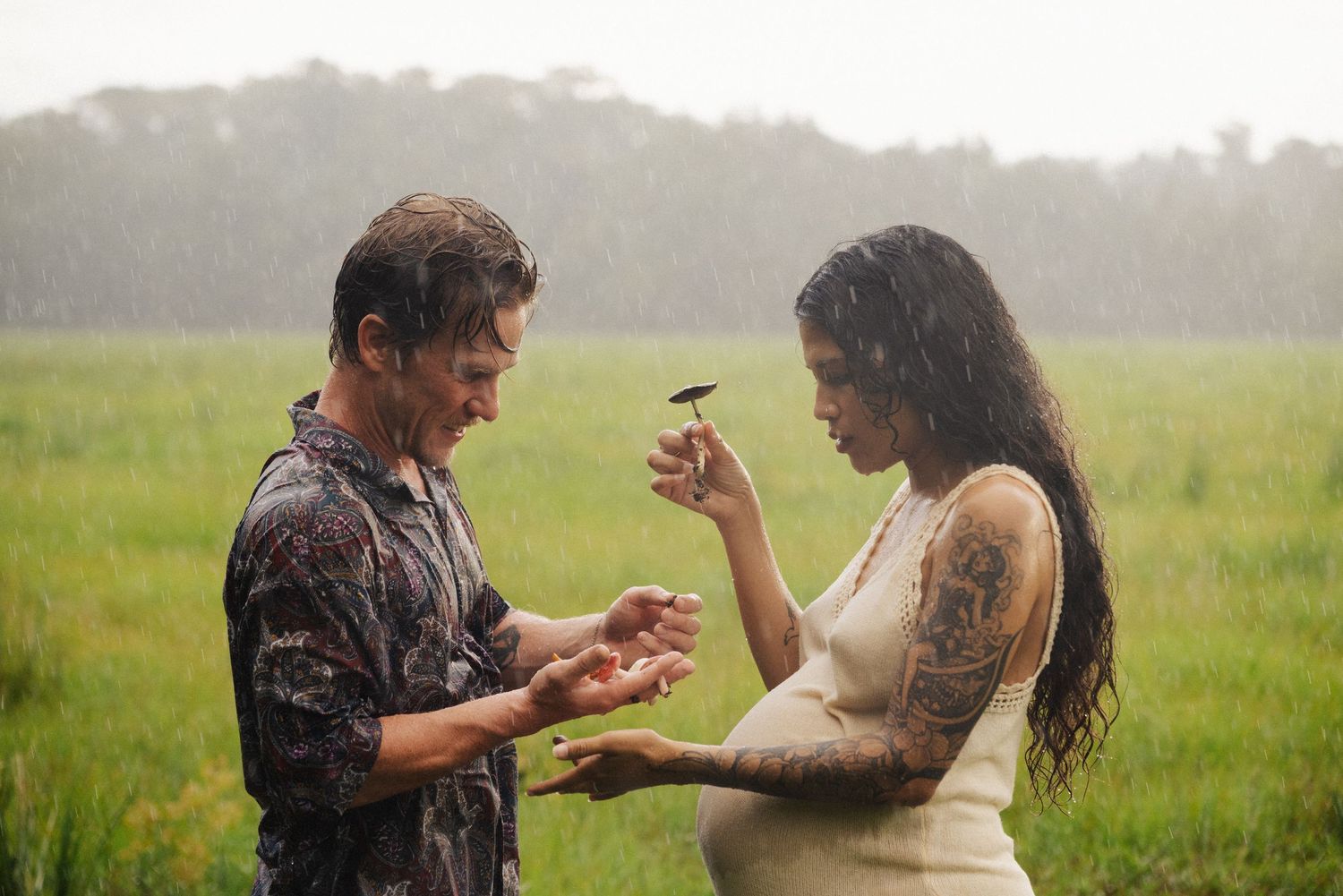 A couple laughs together in the rain during an outdoor photoshoot.