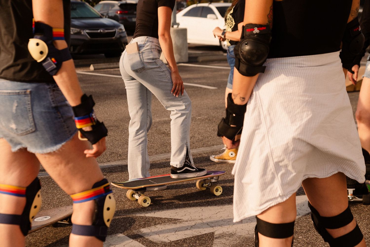 Multiple pairs of legs on skateboards showing various riding stances.