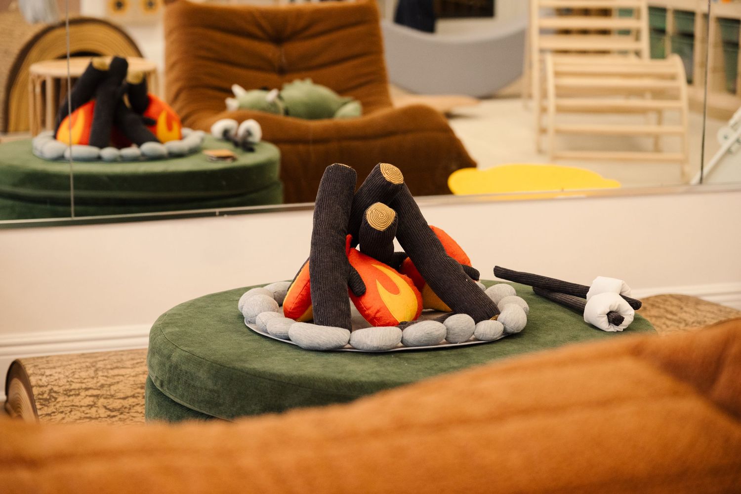 Soft toys and decorative items displayed on a cozy orange couch.