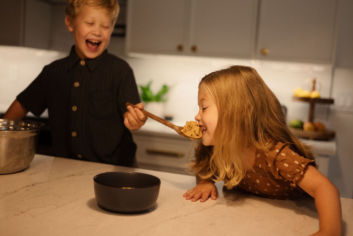 A sequence of candid shots showing joyful interactions in a home kitchen setting.
