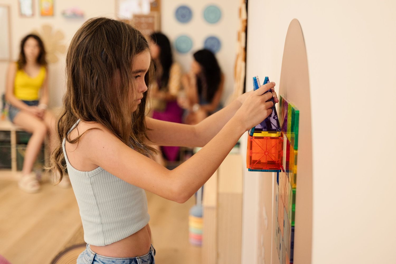 Student working on an educational activity board mounted on a wall.