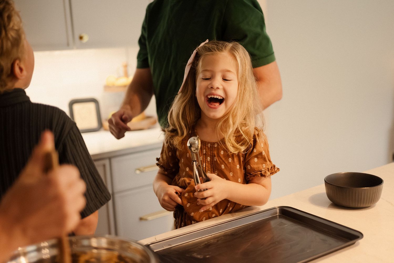 Children helping with baking preparations at a kitchen counter.