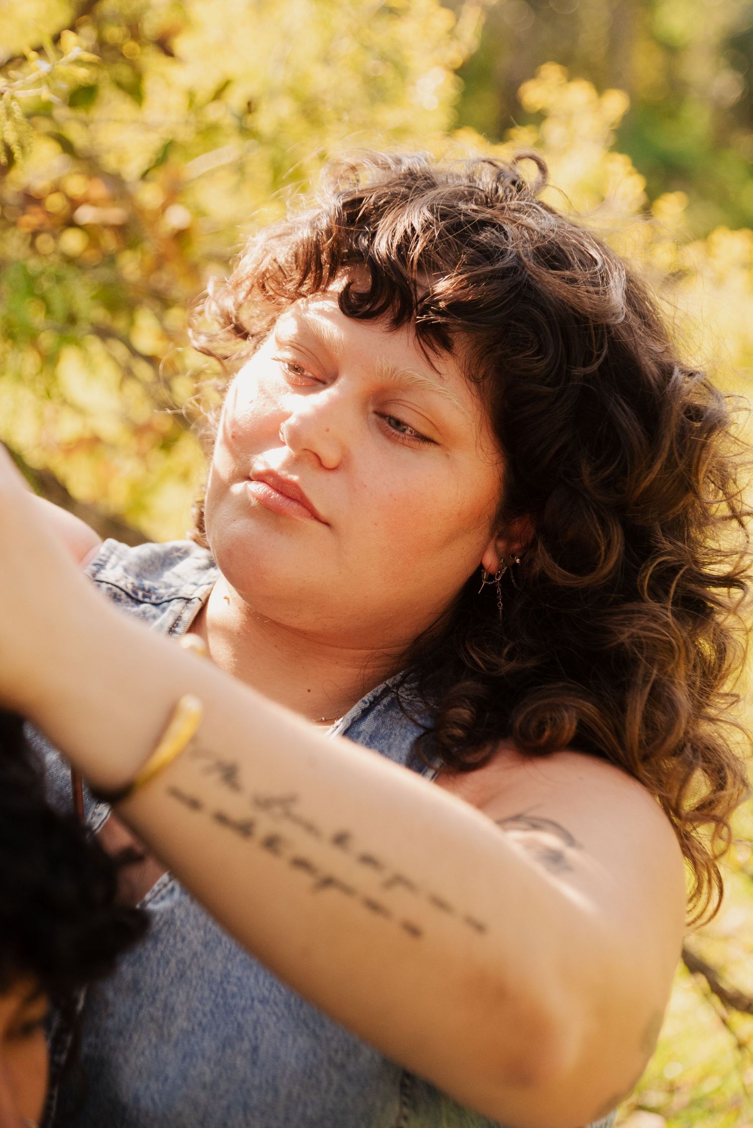 Dreamy outdoor portraits with tattoo details and natural sunlight.