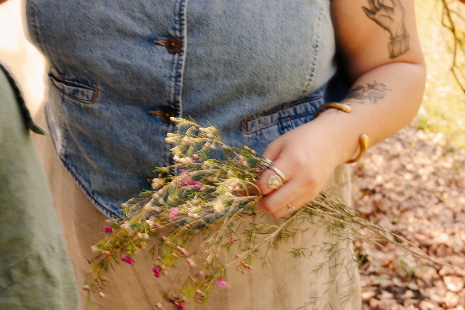 Detail shots of denim clothing and tattoos in warm outdoor lighting.