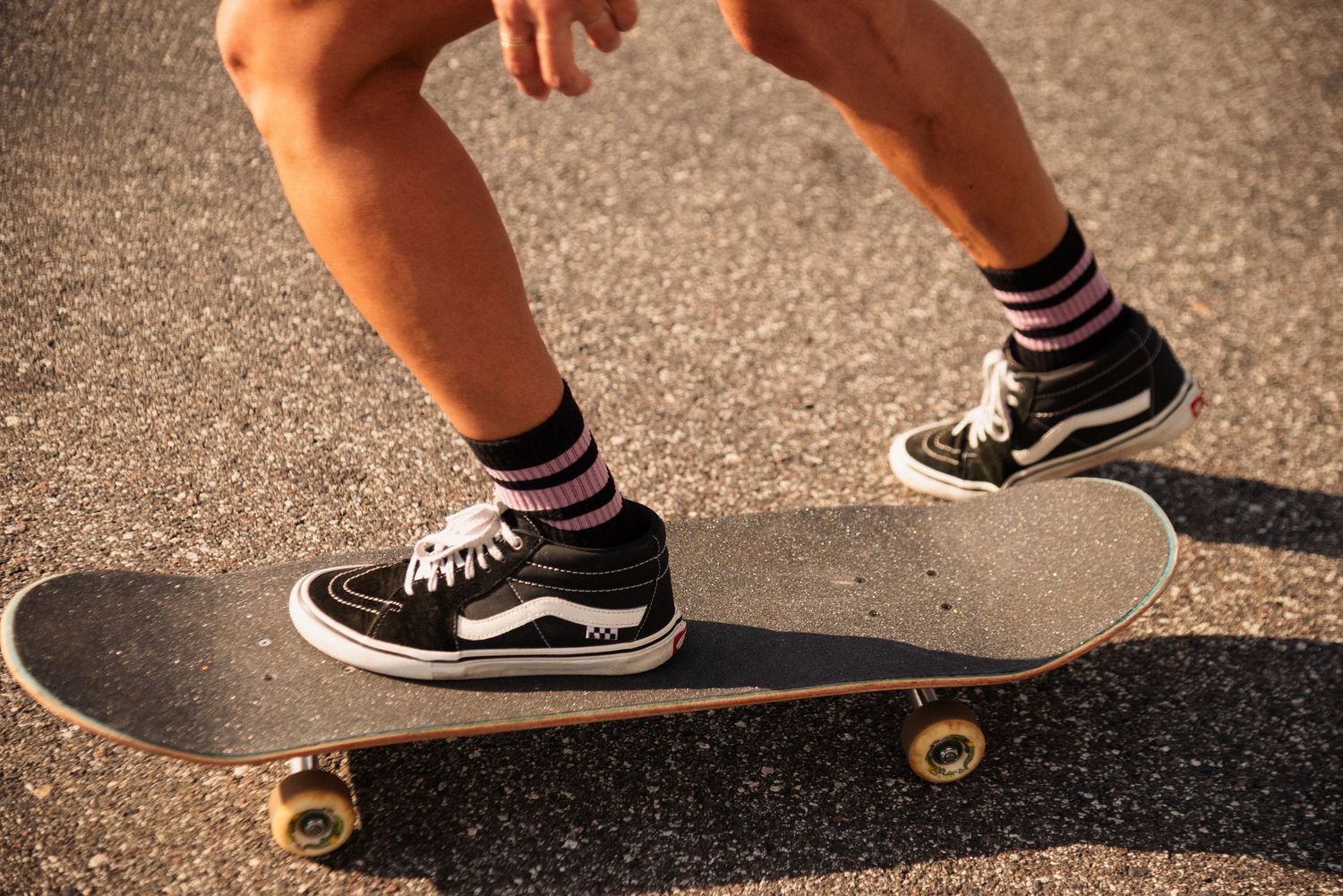 Sequence of skateboarding tricks shown through multiple frames on asphalt.