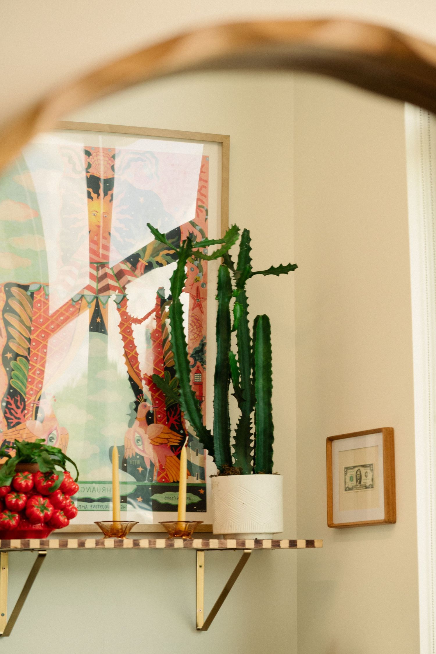 Shelf display featuring cacti plants and colorful artwork in a modern interior setting.