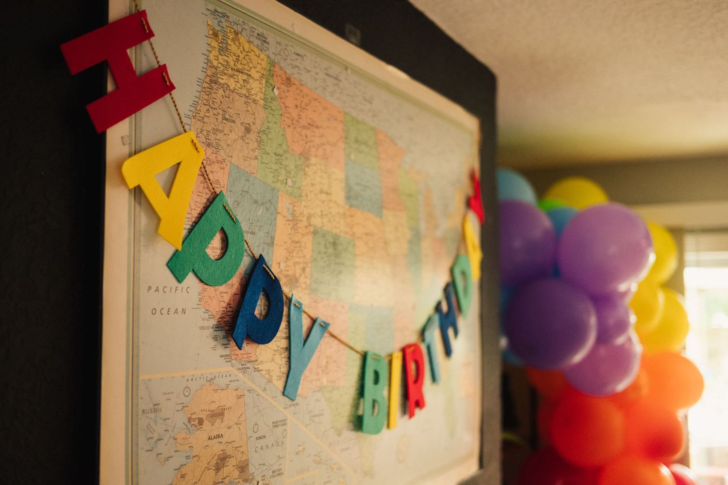 Colorful party decorations with banner and world map on wall.