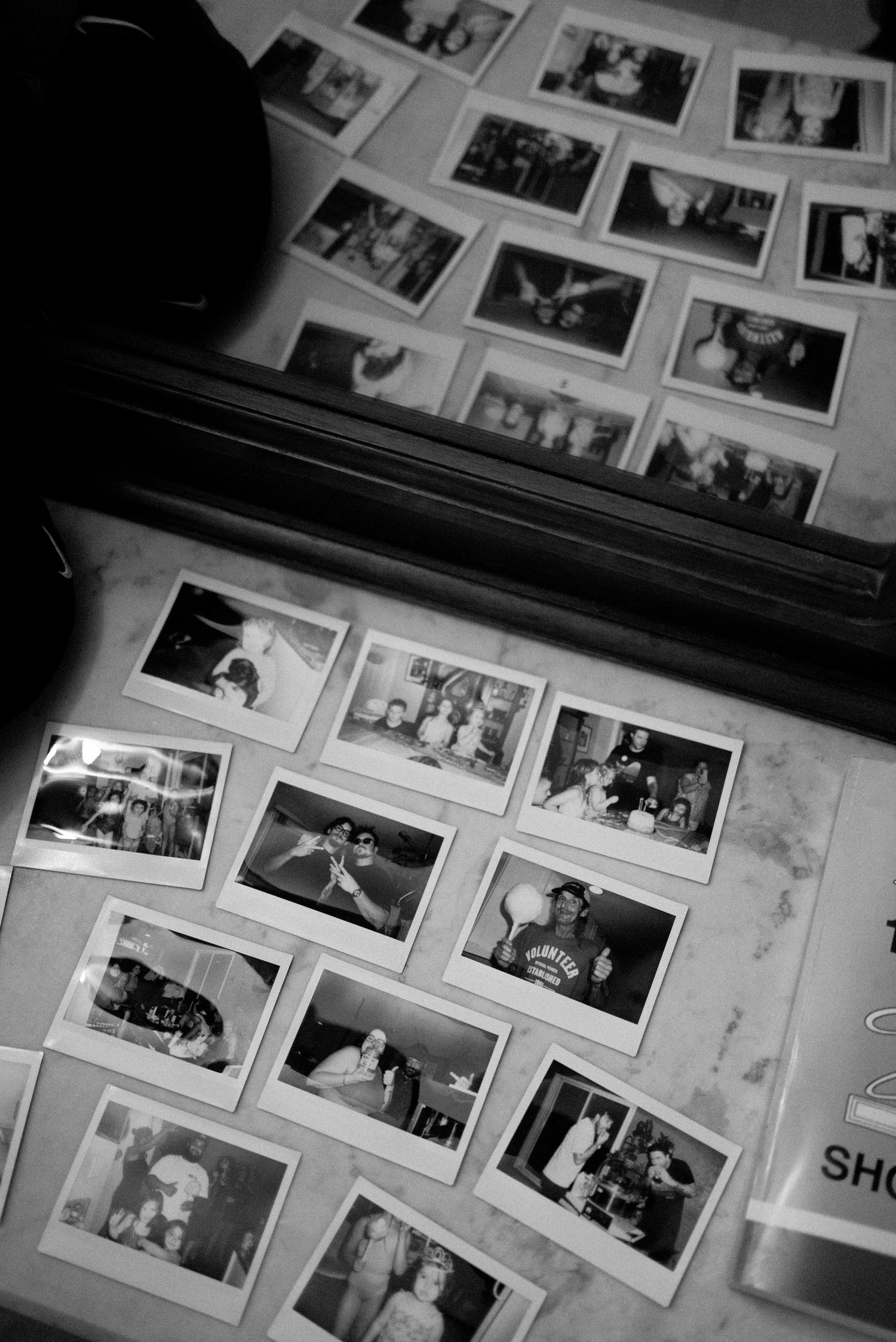 Black and white collection of photographs spread out on a surface.