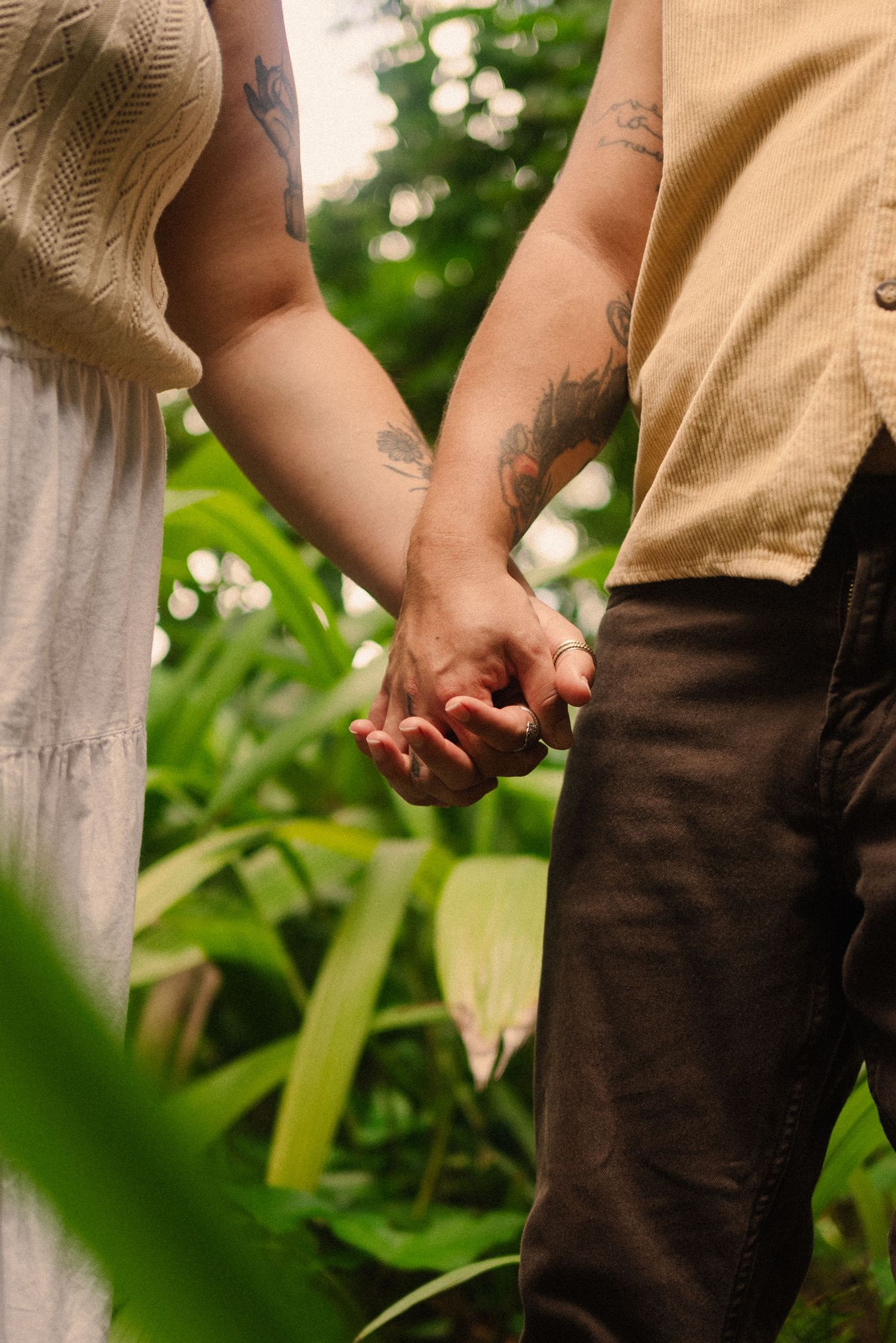 Close-up of hands against green foliage in natural outdoor lighting.