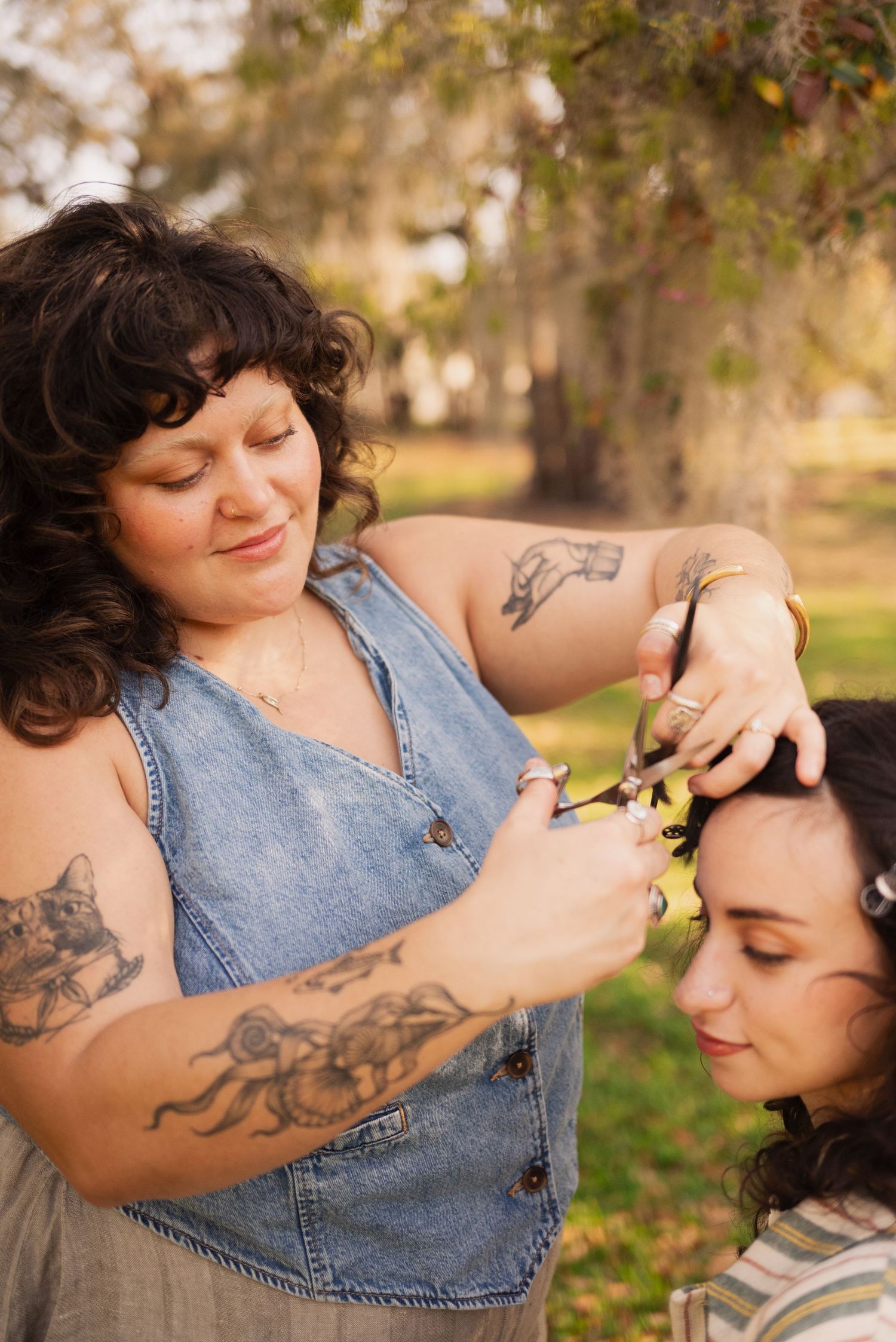 Candid outdoor photoshoot featuring denim clothing and visible tattoo art in golden lighting.