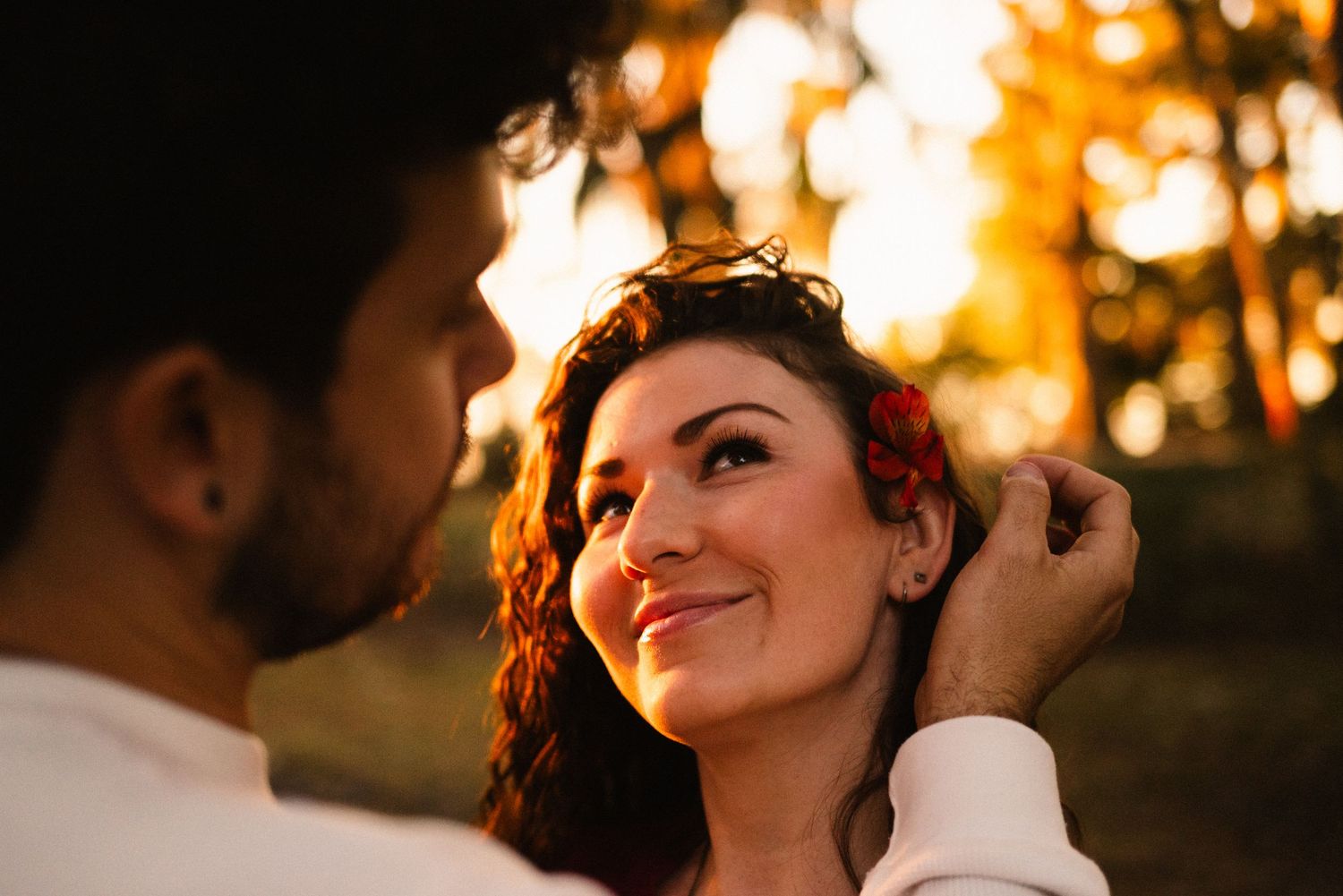 A romantic photoshoot captures tender moments between a couple at golden hour.
