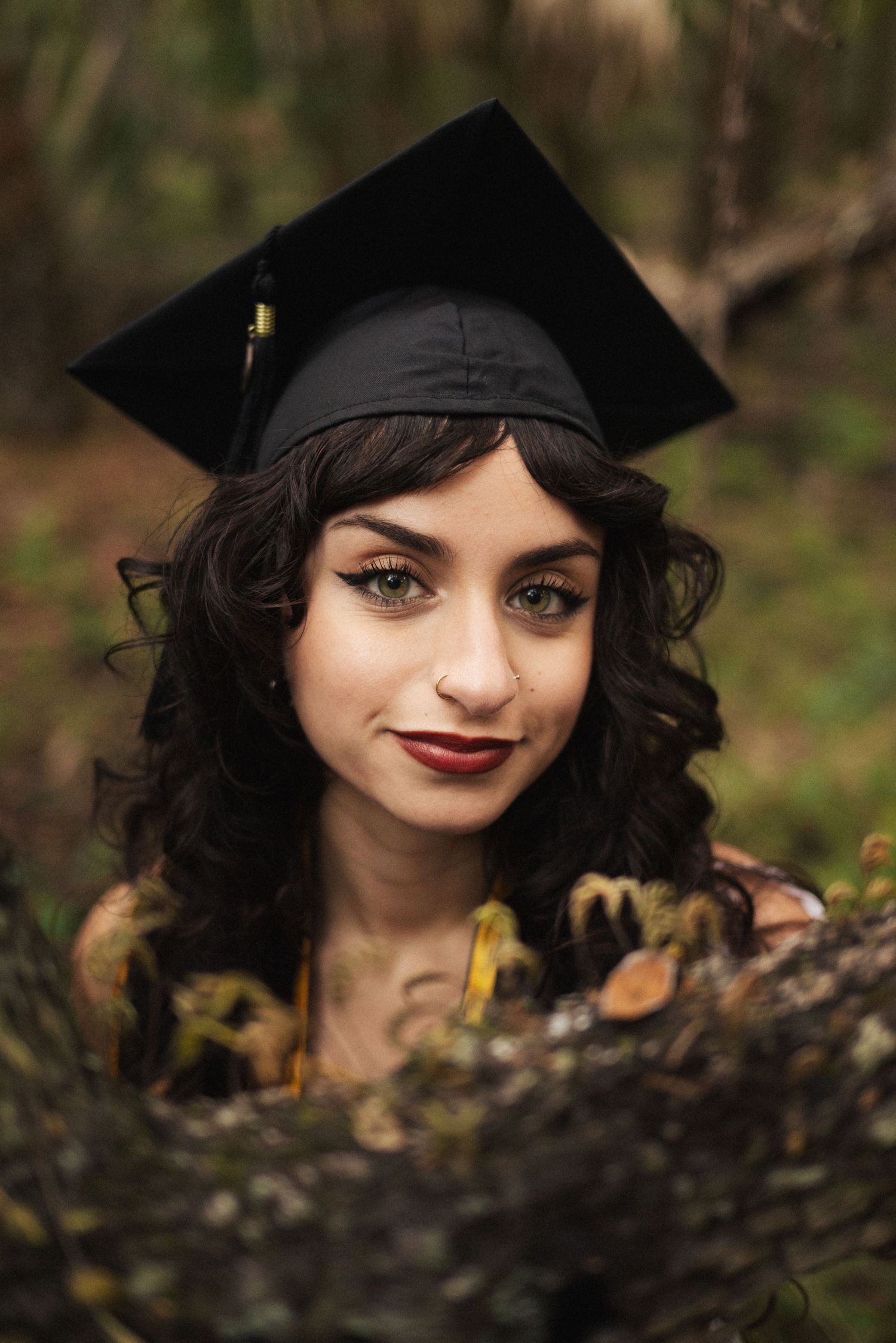 Close-up graduation photos showing a black cap and dark curly hair.