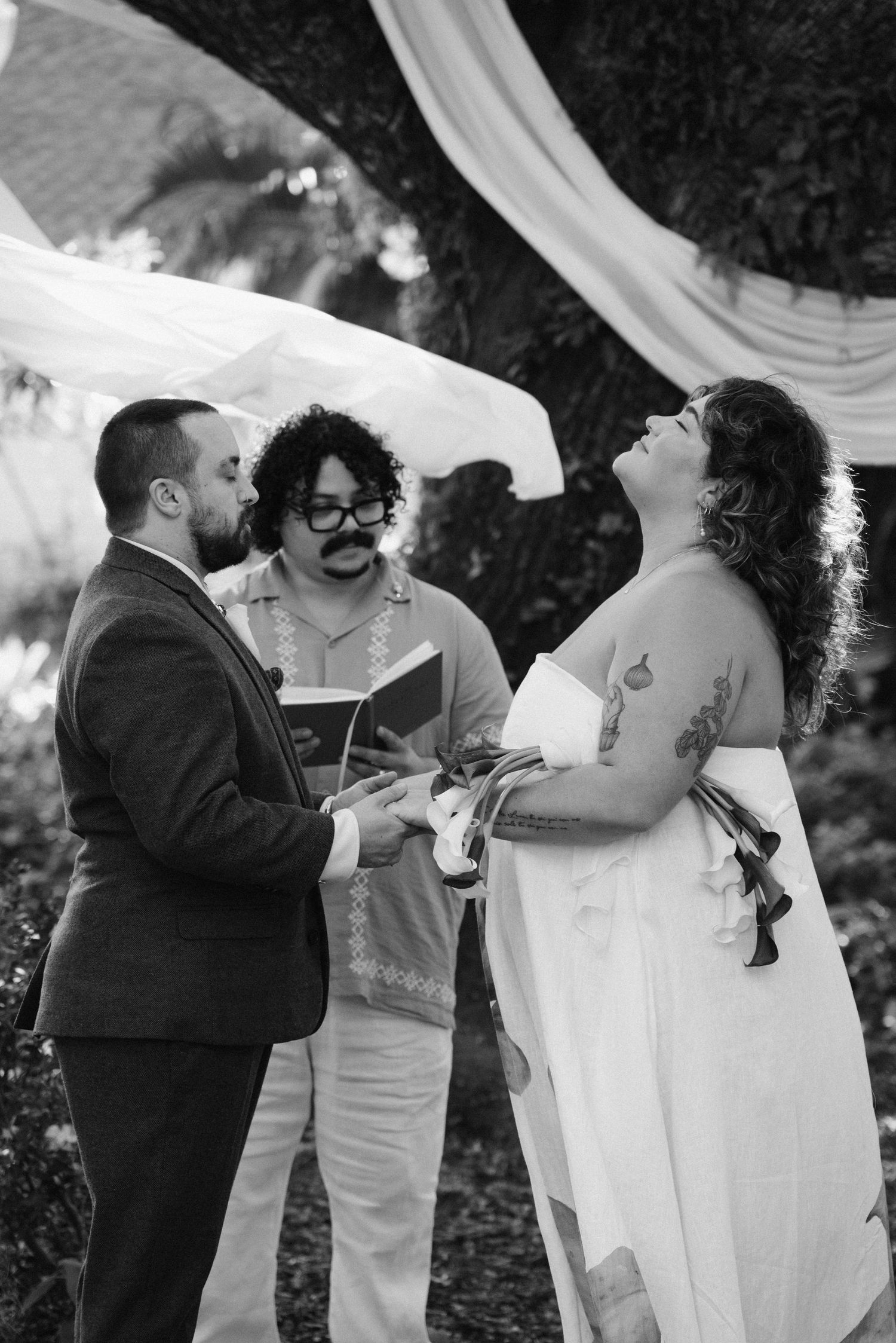 Wedding ceremony participants share emotional moments during outdoor celebration.