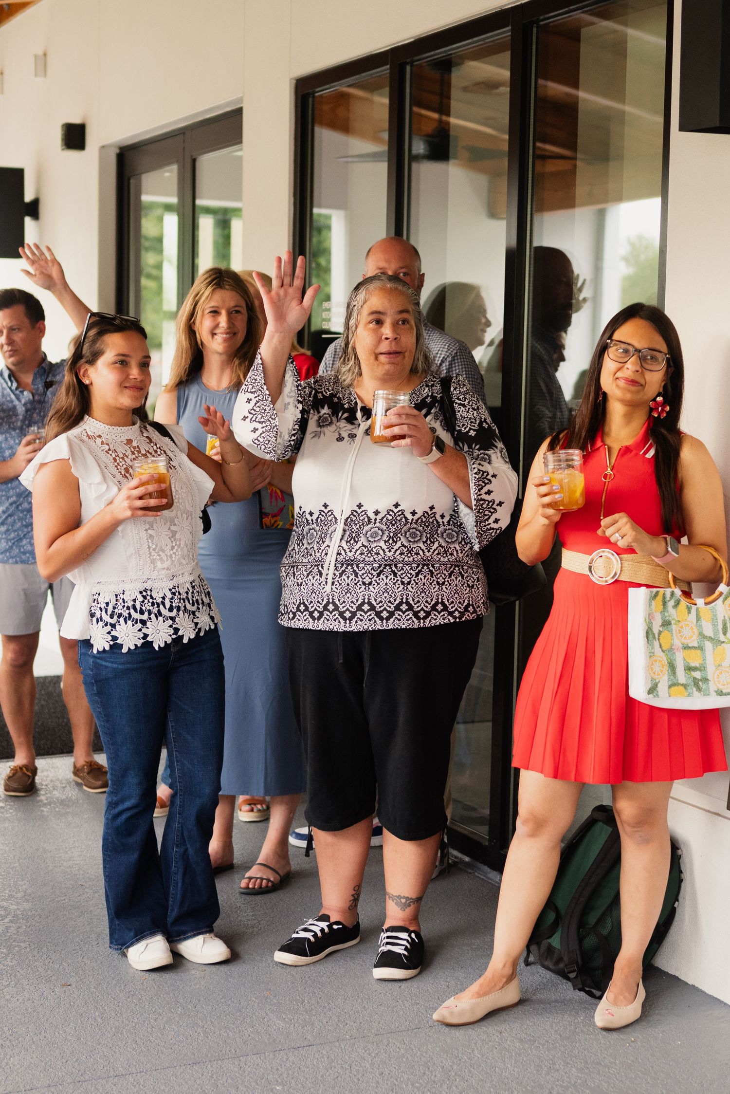 A group of people on a covered patio raising their drinks in a celebratory toast.