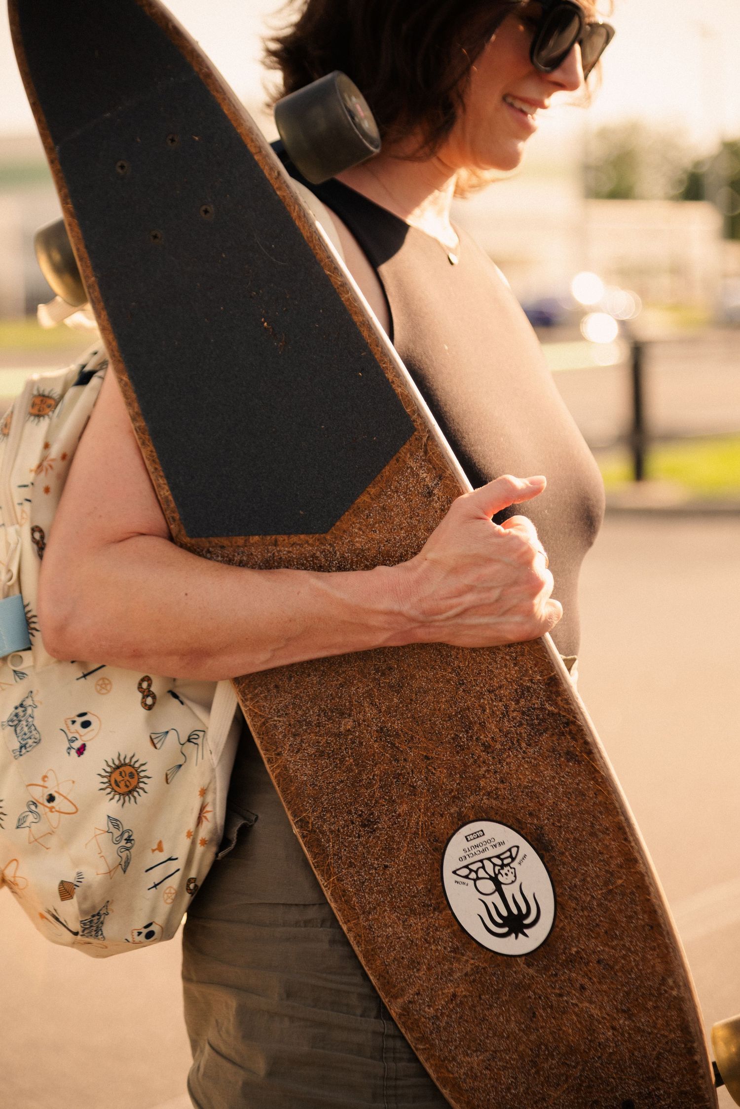 Close-up of a skateboard with a menorah logo emblem against rustic texture.