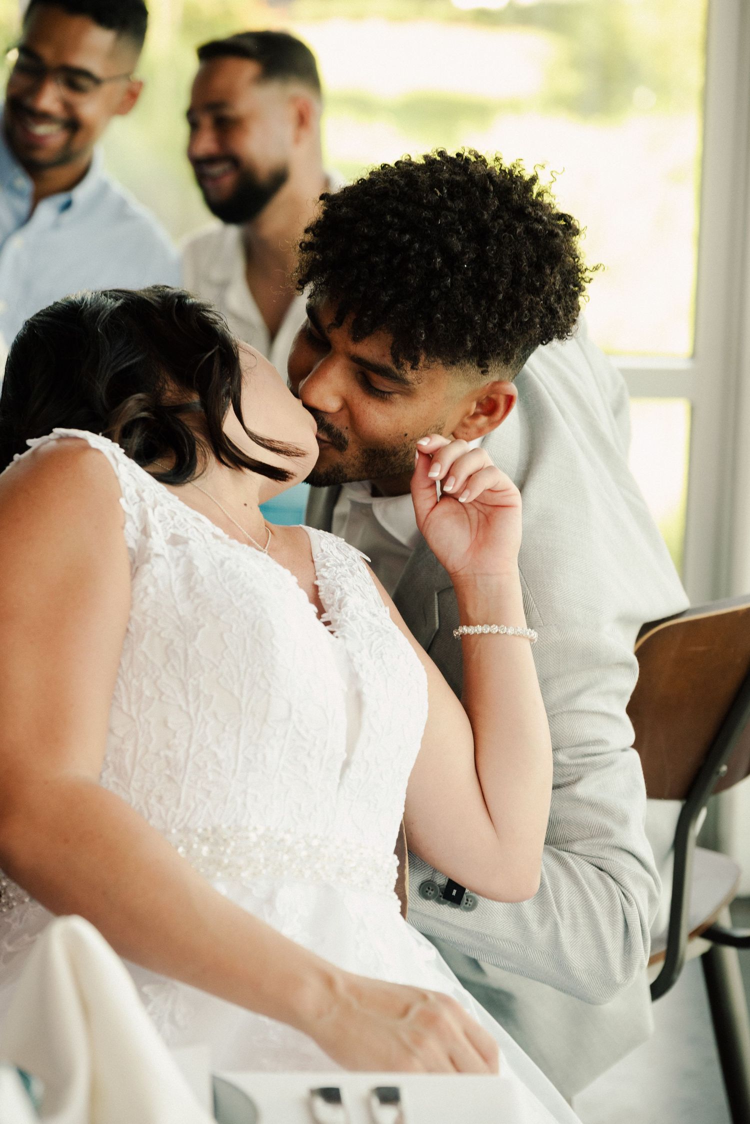 Candid moments between wedding couple in white and light colored attire.