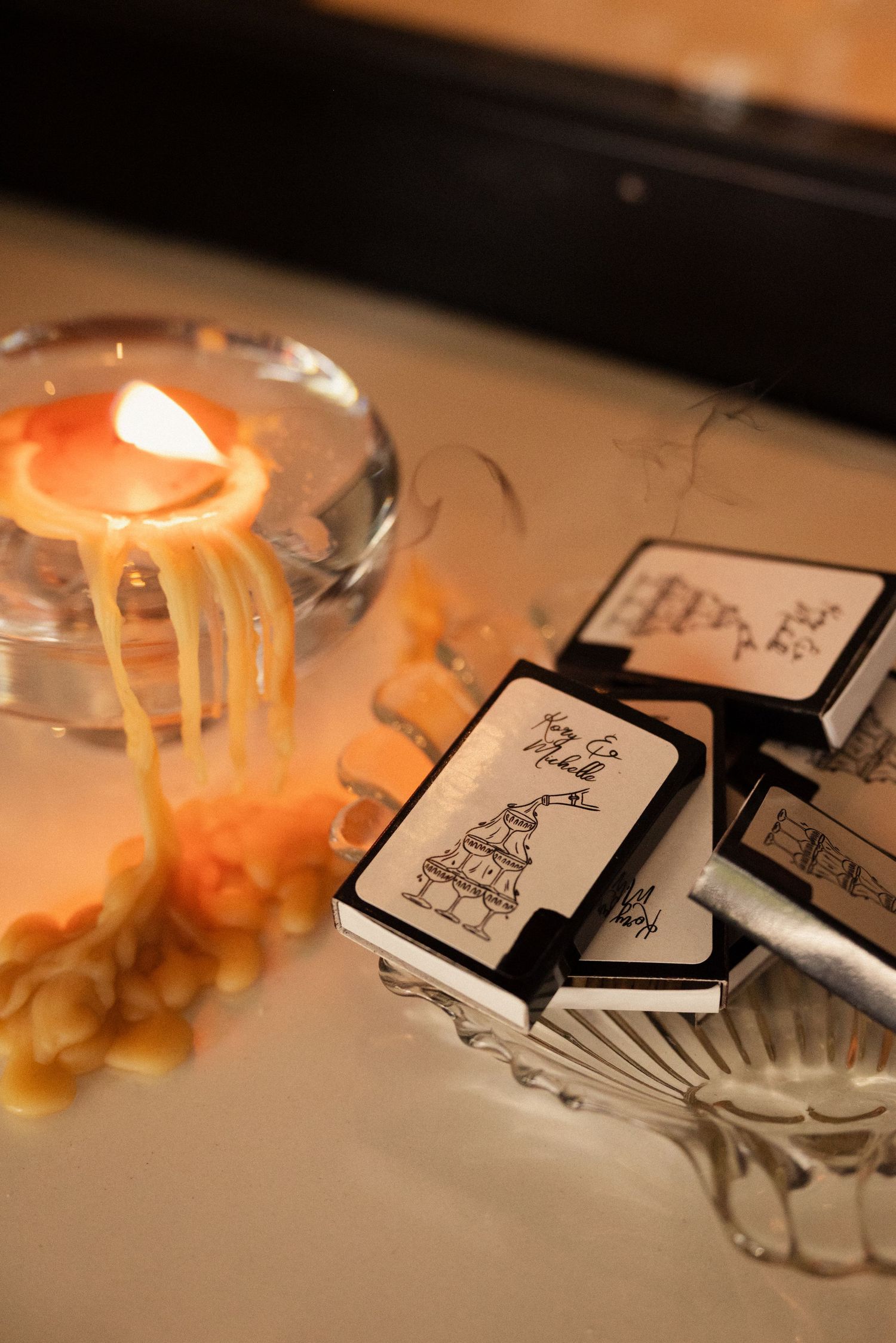 Lit candle and decorative cards on a table at a wedding reception.