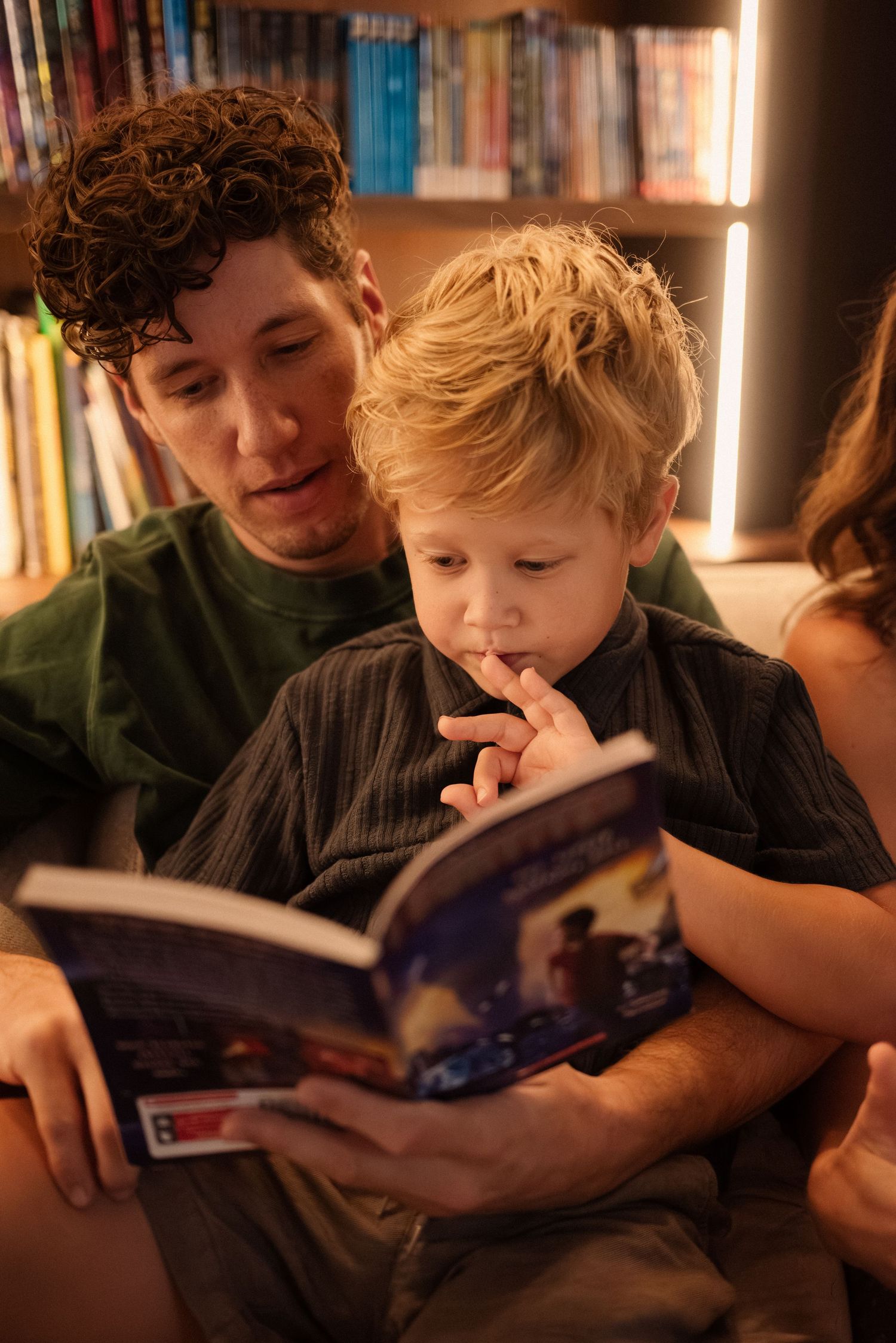 A cozy reading session with books in front of well-stocked bookshelves.