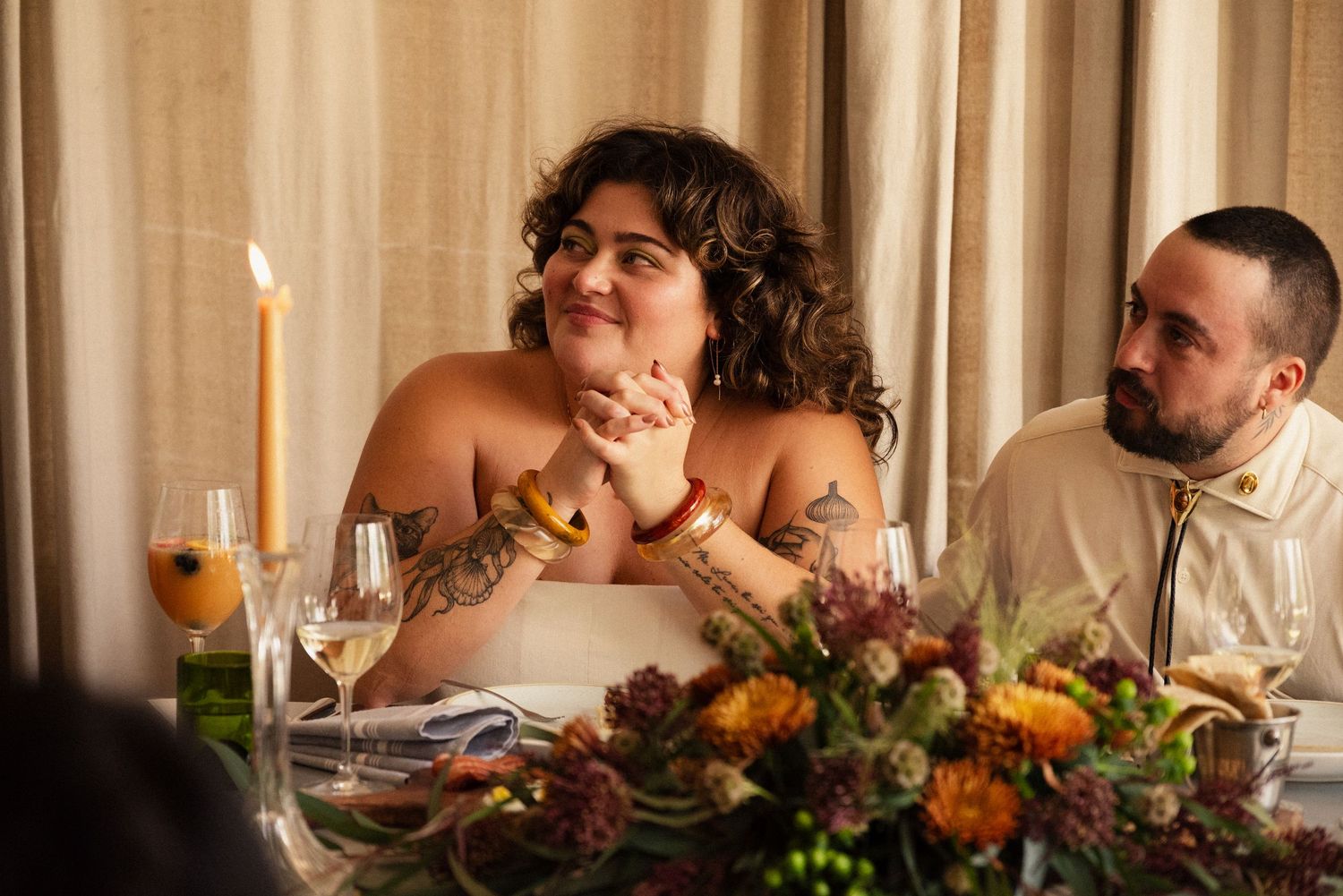 A couple shares a candlelit dinner moment at their wedding reception.