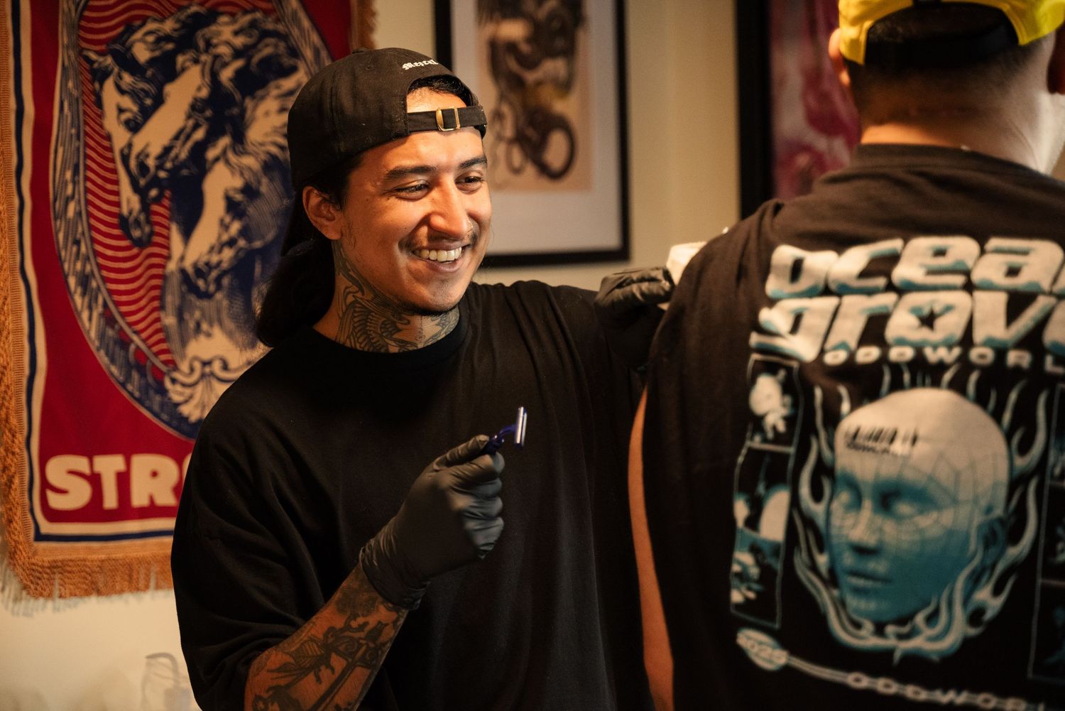 Tattoo artists working together in a professional studio environment.