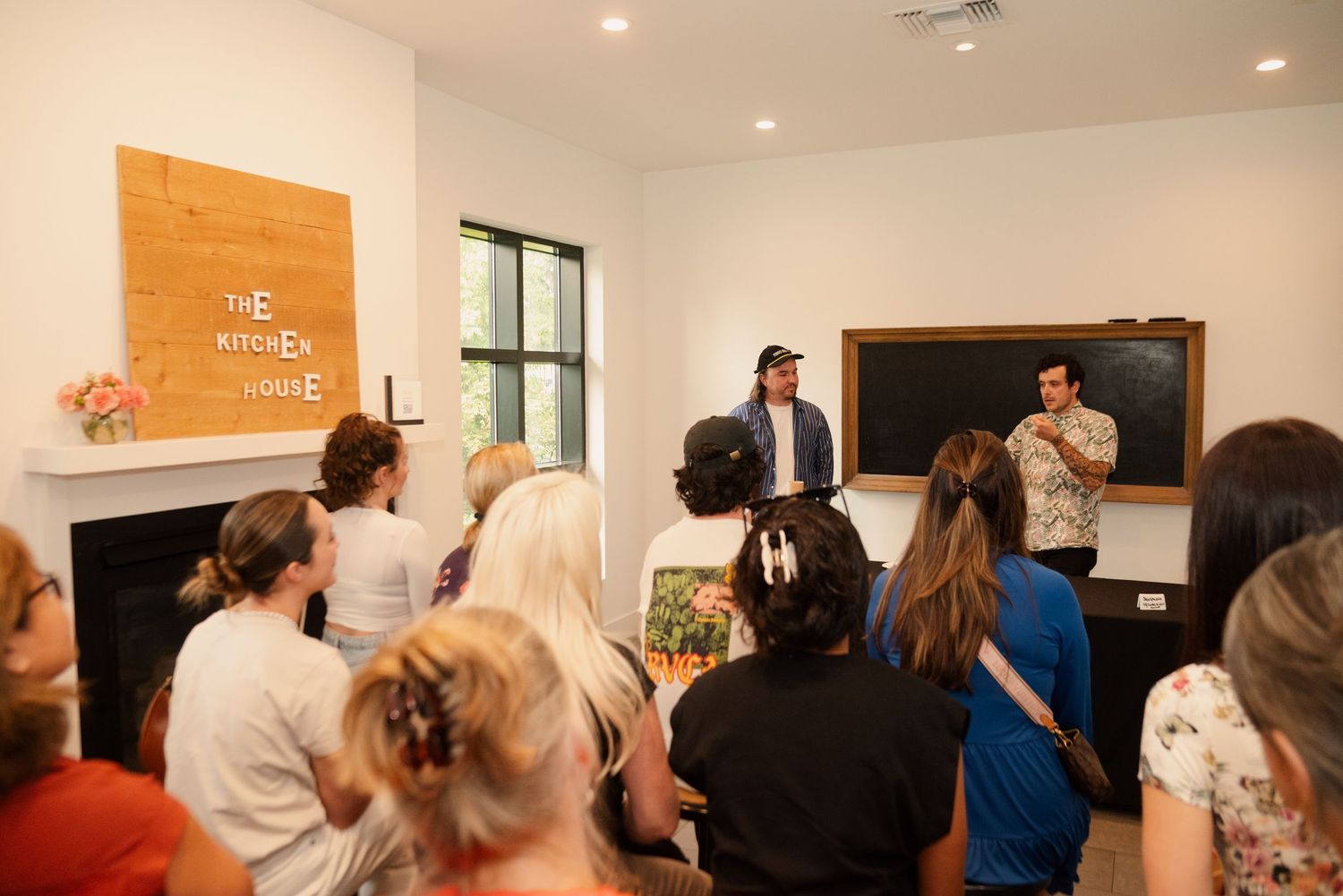Panoramic view of a bright meeting room with wooden accents and engaged audience members.