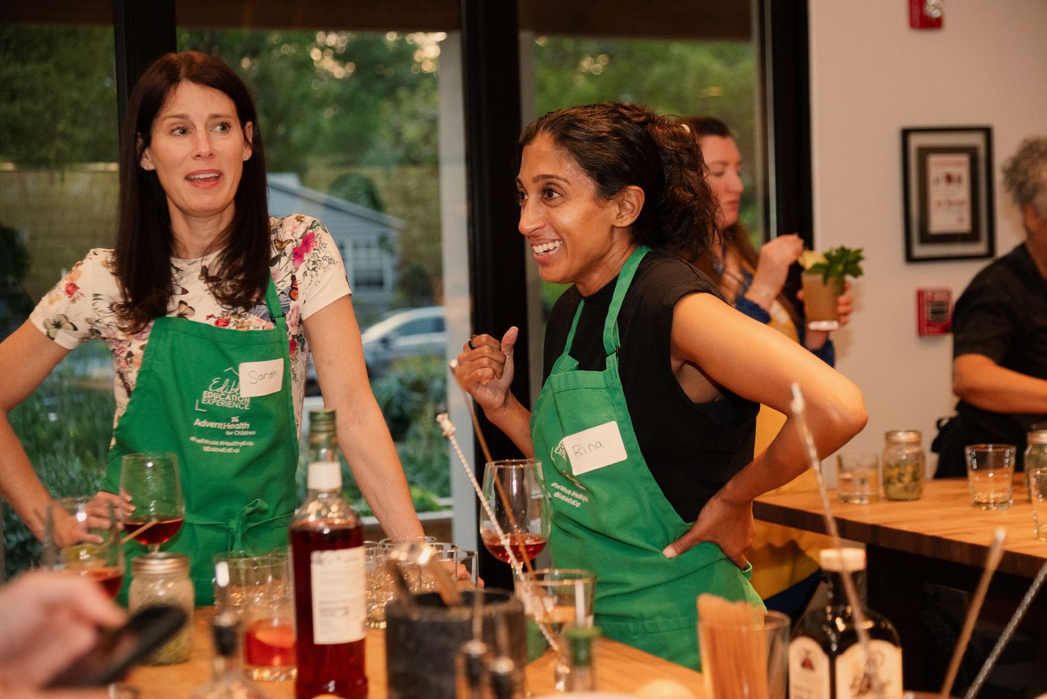 Group in green aprons participating in an interactive cooking workshop.