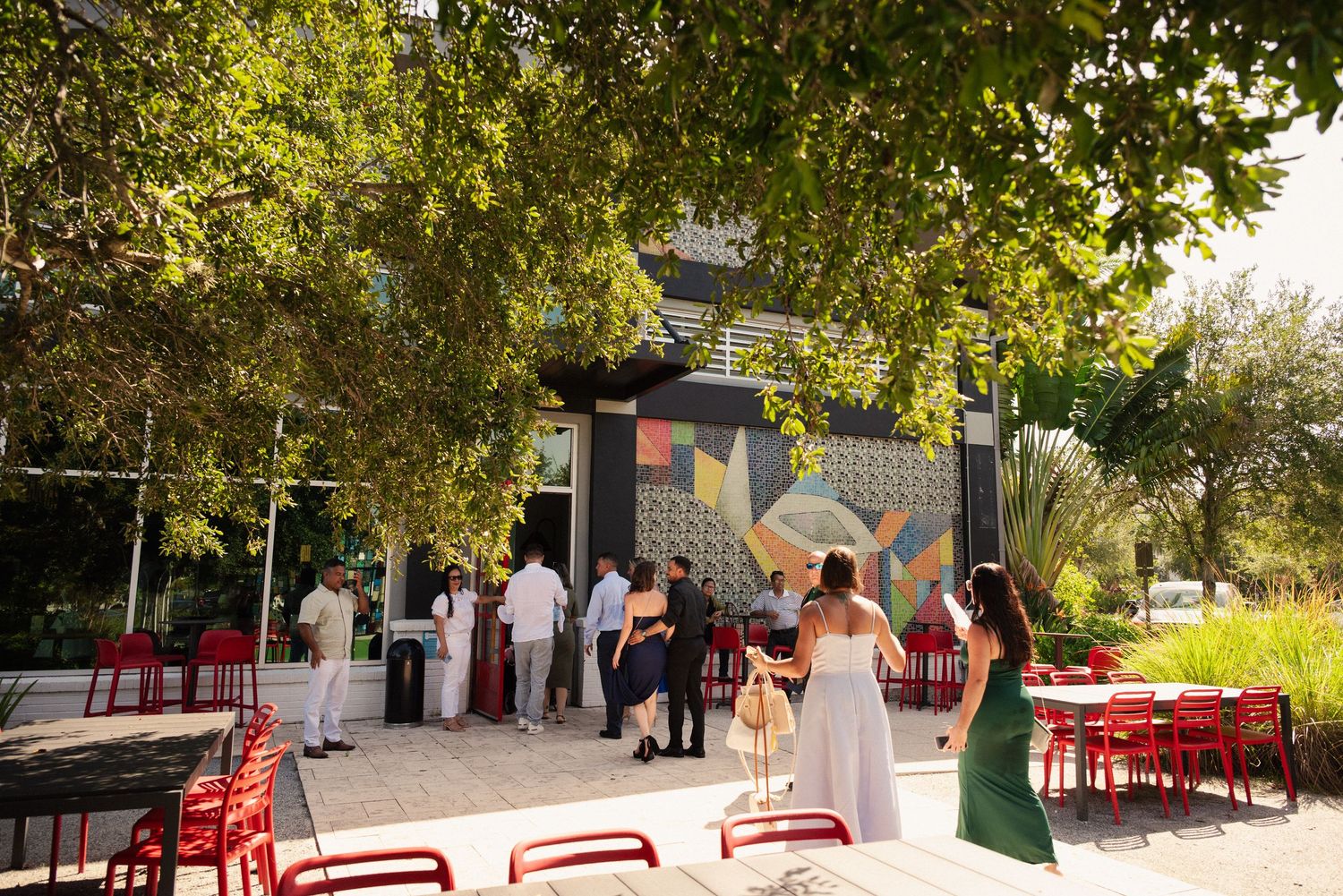Scenic outdoor wedding venue with red chairs and natural landscaping.