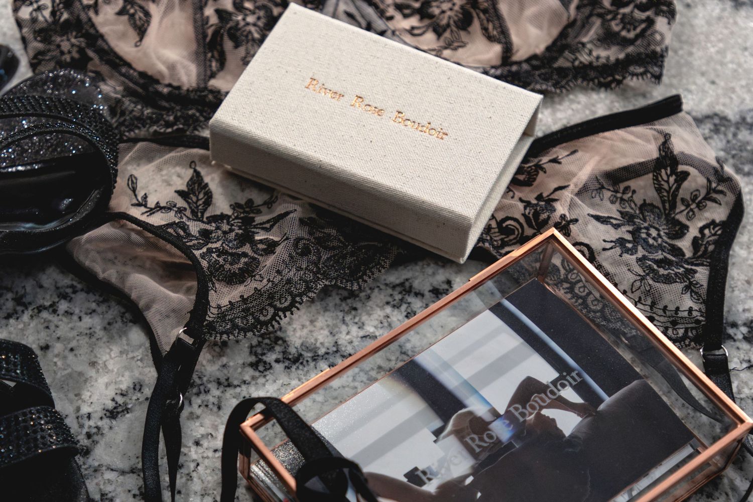 Elegant photo album with copper binding and white cover displayed with scattered black and white photographs.