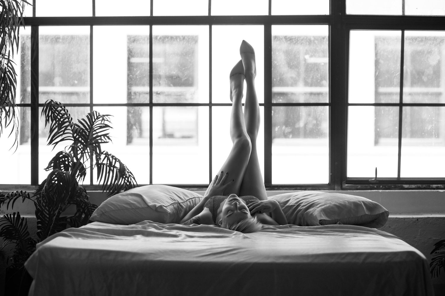 Black and white artistic photo series showing silhouettes against large windows in a minimalist interior setting.