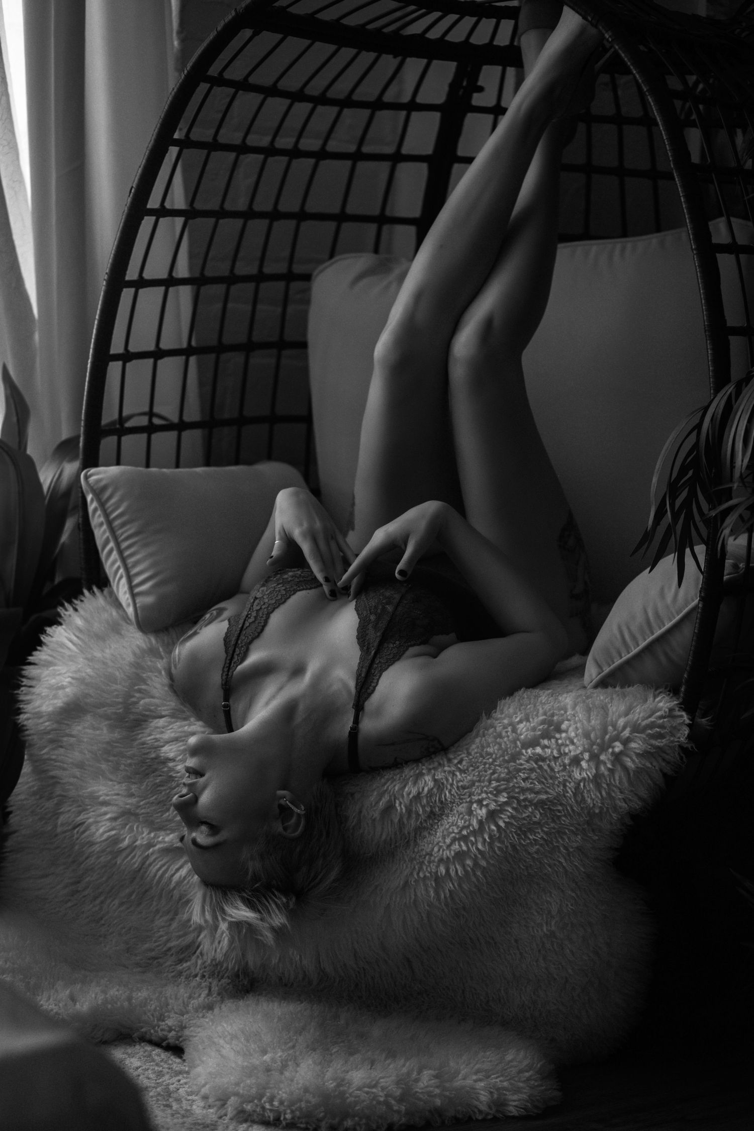 Intimate black and white portrait in hanging chair with faux fur cushions.