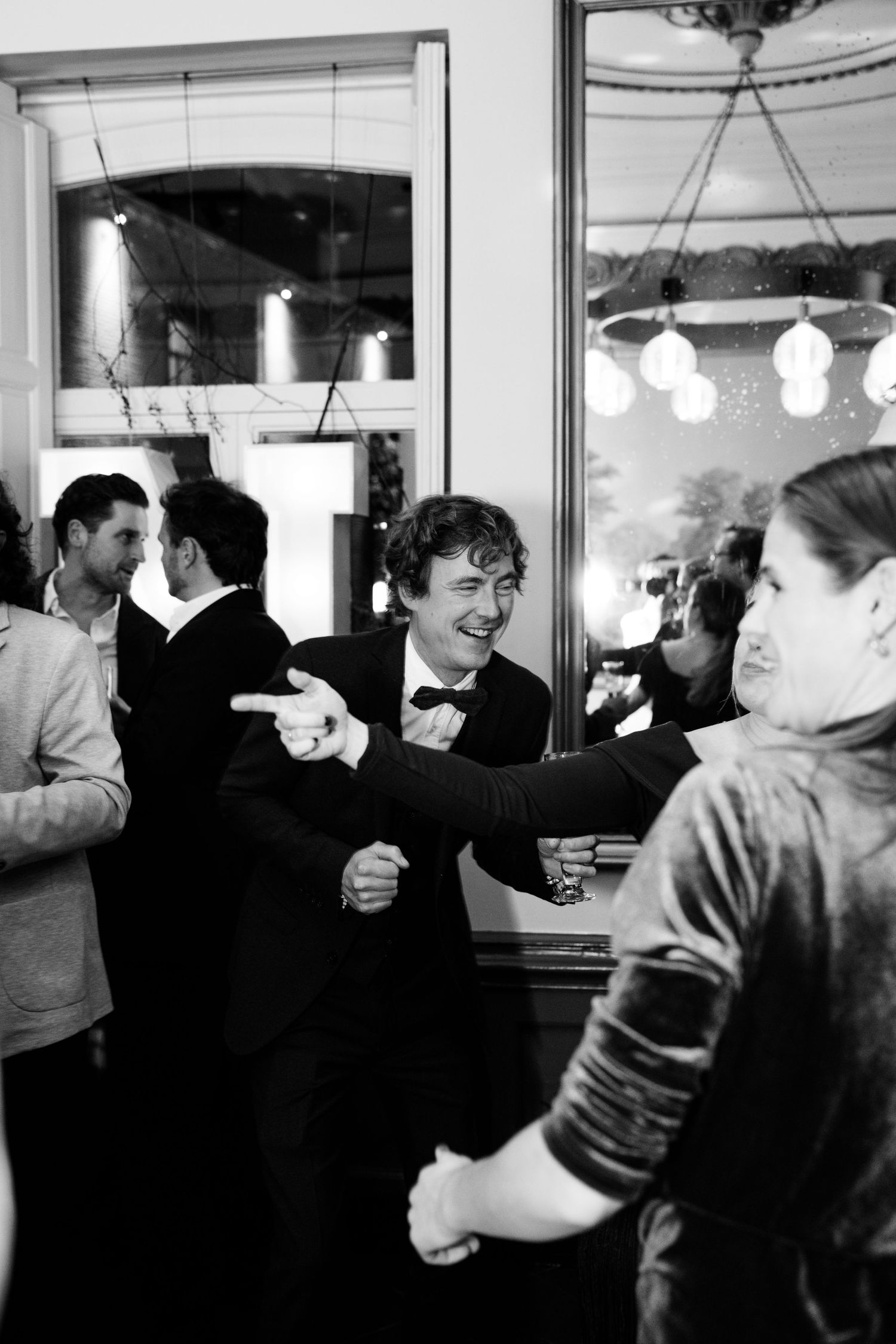 A sequence of black and white photos showing people socializing and drinking at a bar or pub.