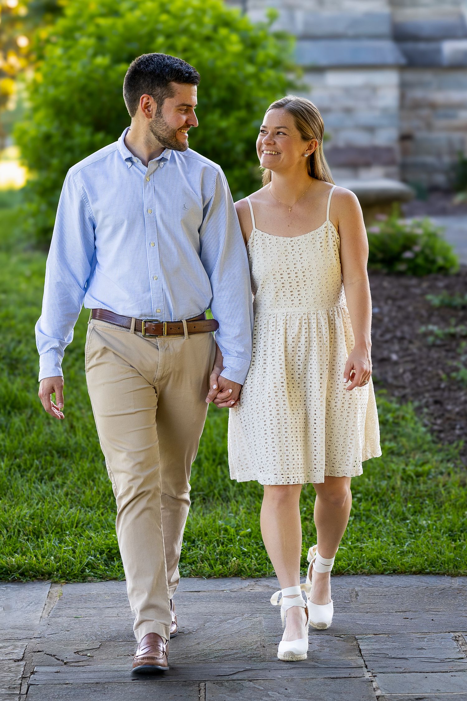 A newly engaged couple laughing together during a golden hour engagement photography session.