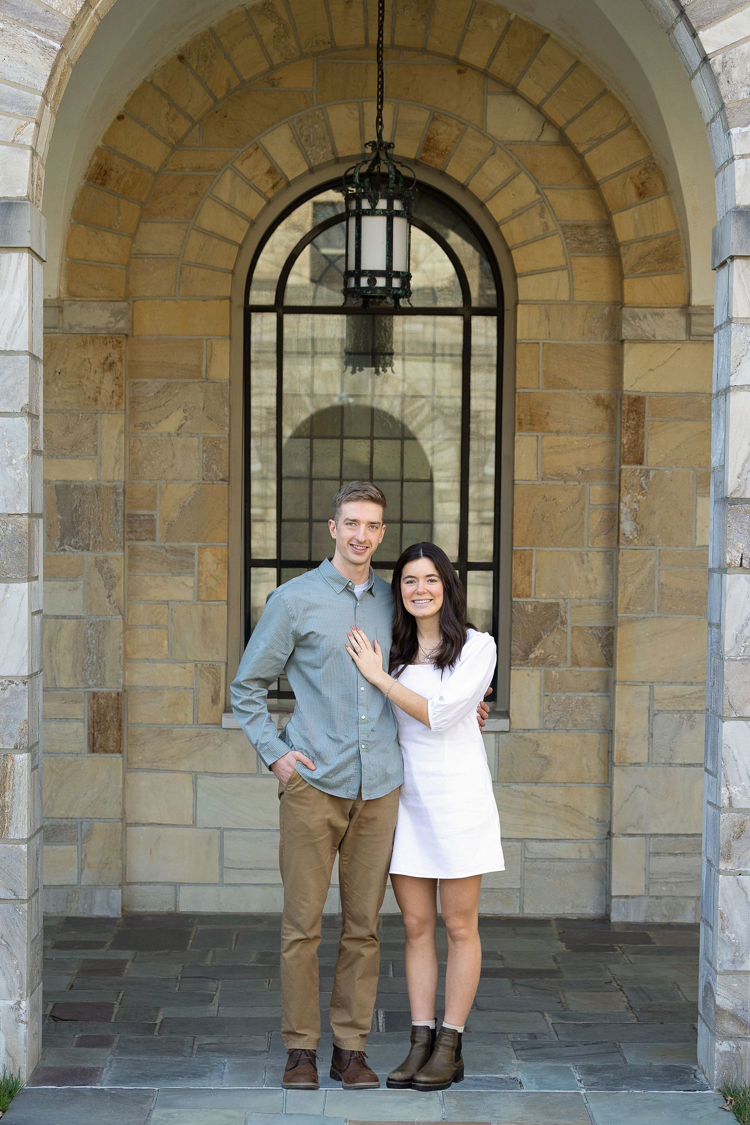 A newly engaged couple laughing together during a golden hour engagement photography session.