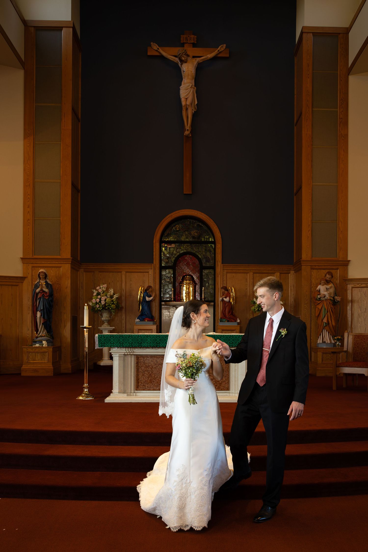 Bride and groom taking bridal portraits after the Sacrament of Holy Matrimony at a Catholic church.