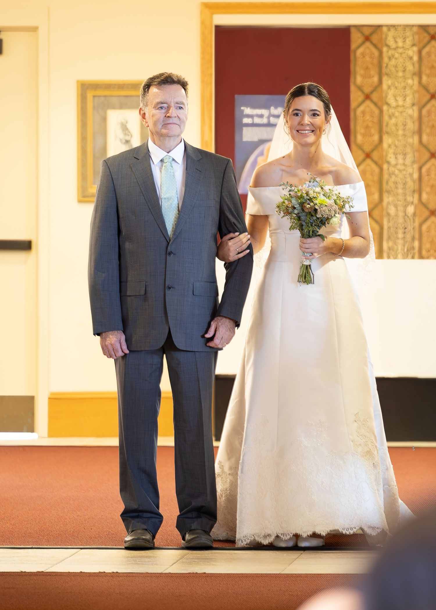 A beautiful bride sitting and smiling before the Sacrament of Holy Matrimony at a Catholic church.