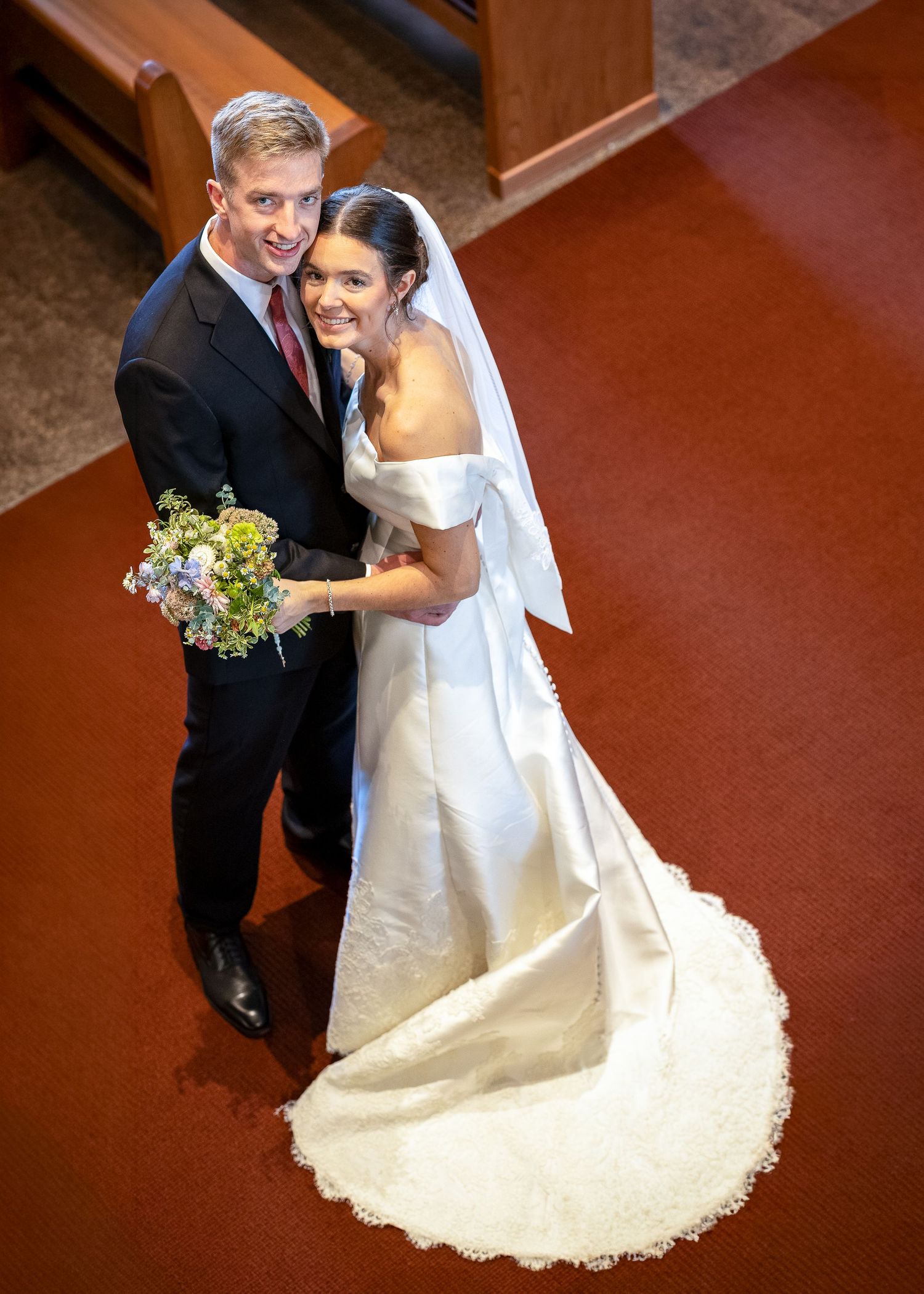 Bride and groom taking bridal portraits after the Sacrament of Holy Matrimony at a Catholic church.