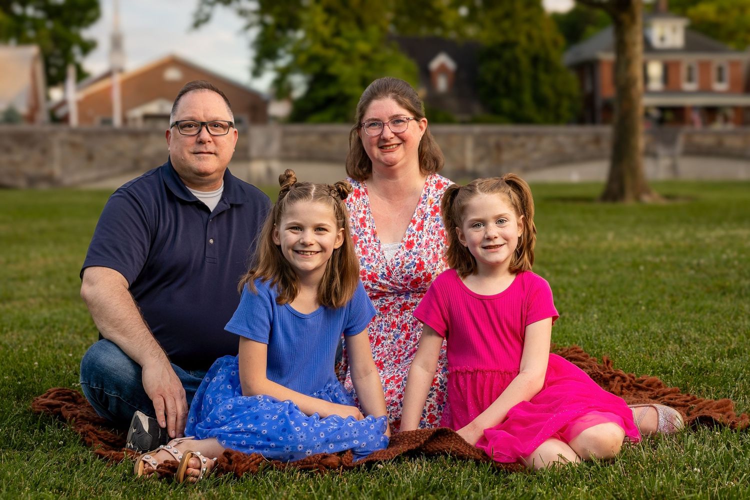 A happy family sitting together during a golden hour photography session.